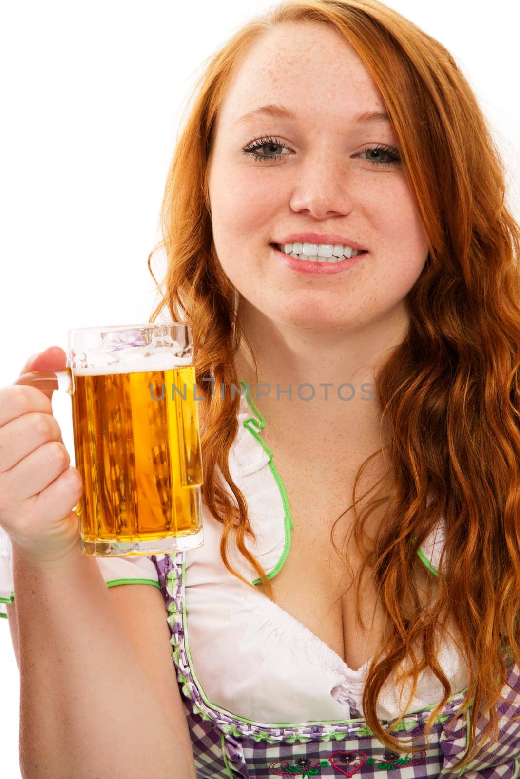 Young woman in dirndl holding beer on white background