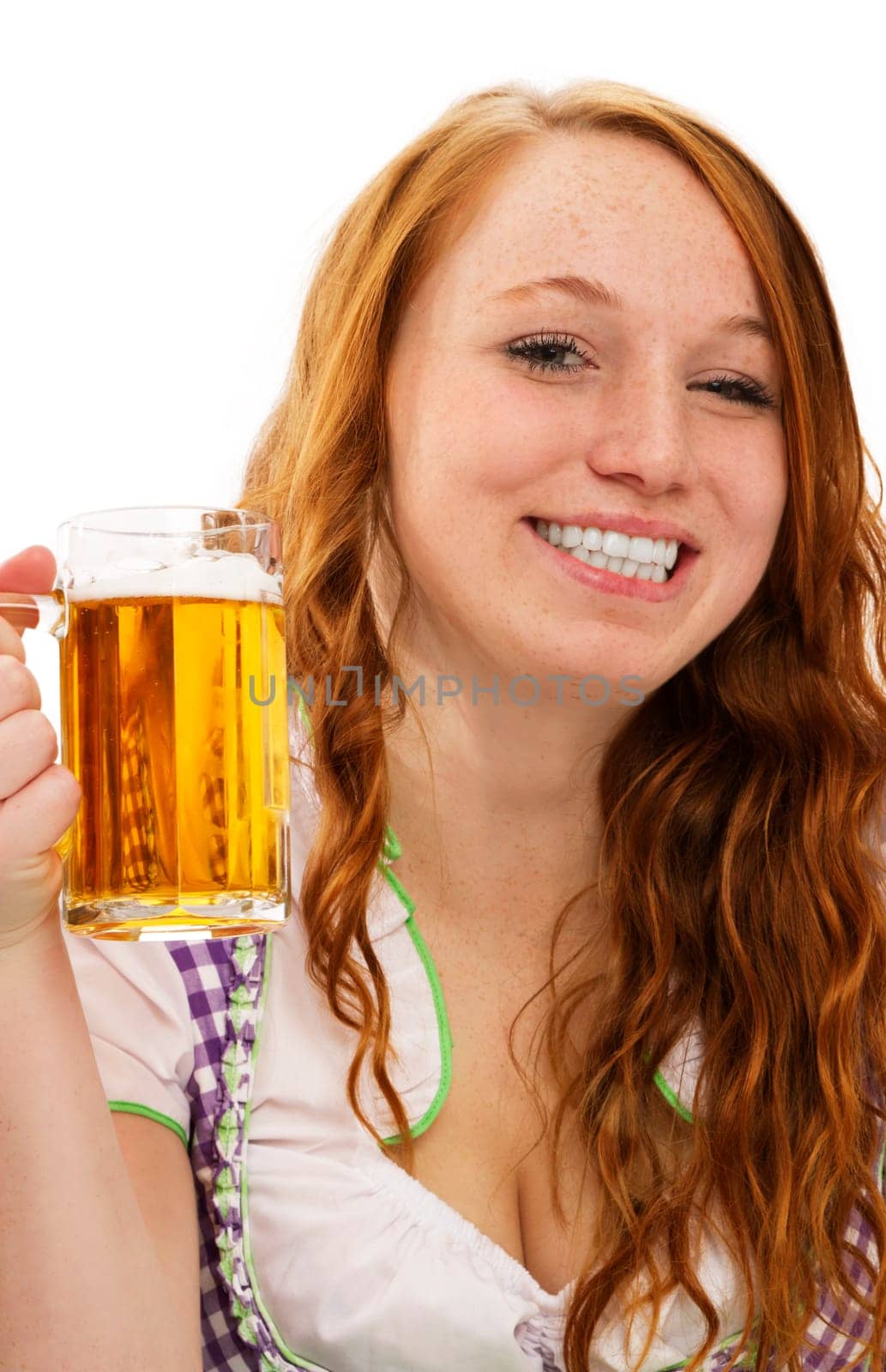 Happy redhead woman in dirndl holding beer on white background