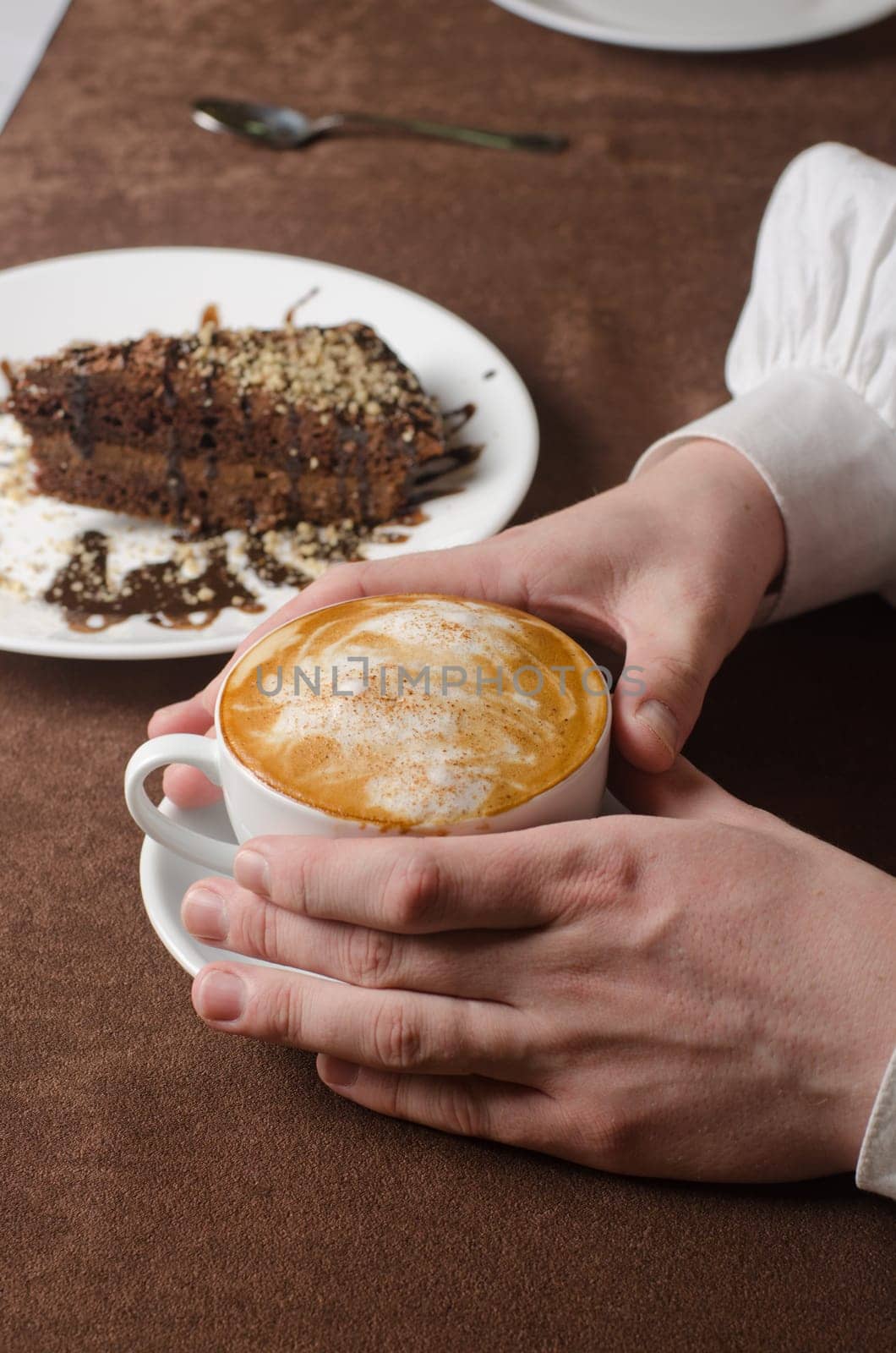 Closeup of female hands holding cup of Cappuccino