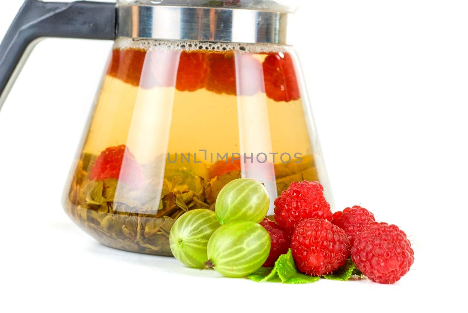 Teapot with fruit tea and berries on a white background