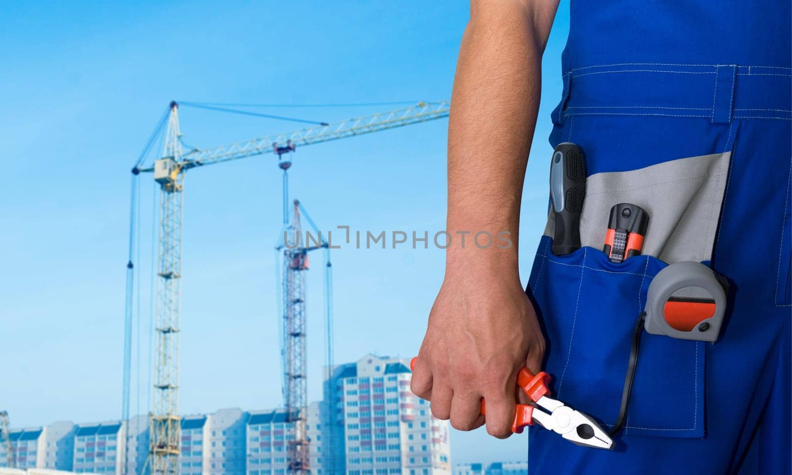 Closeup of repairman with pliers on building background