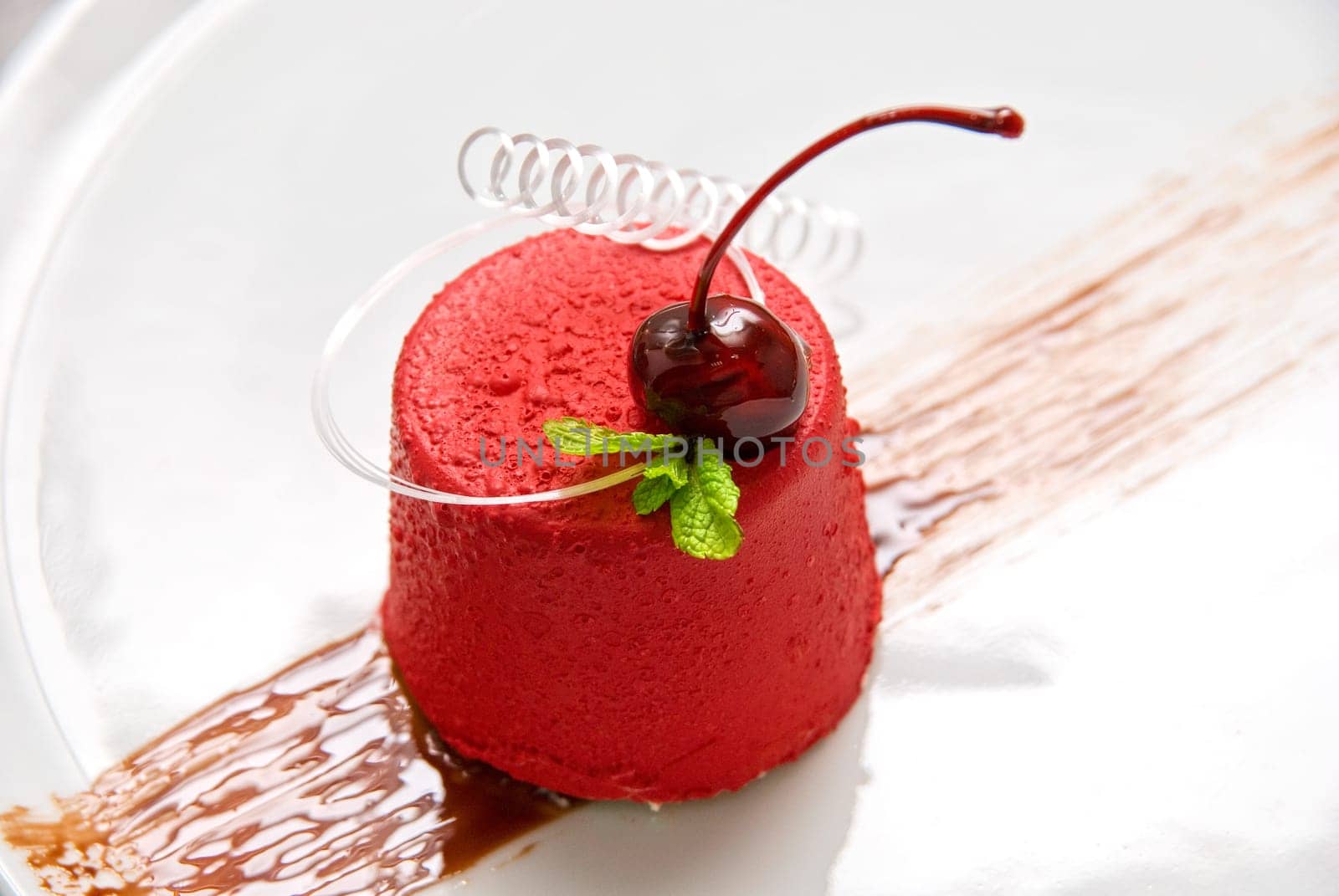 Tasty dessert of whipped cream, chocolate cherry, caramel and mint