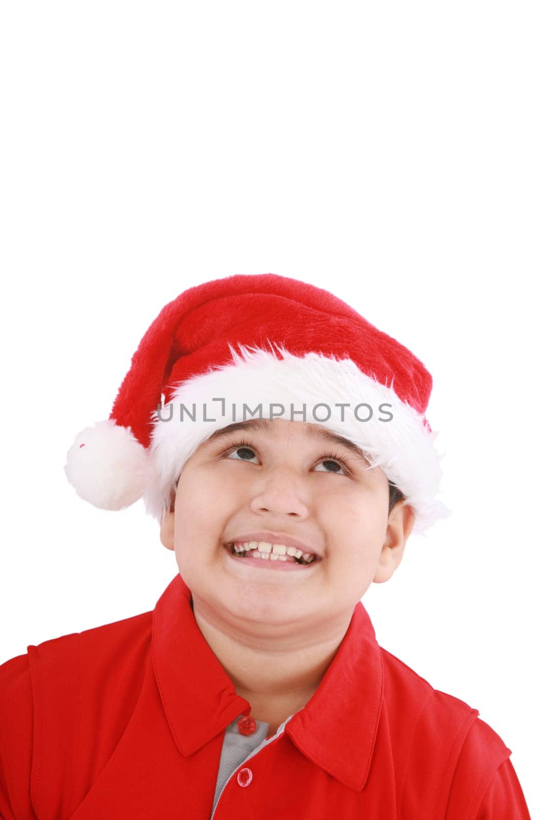 Cute little boy in Santa hat, looking up to copy space