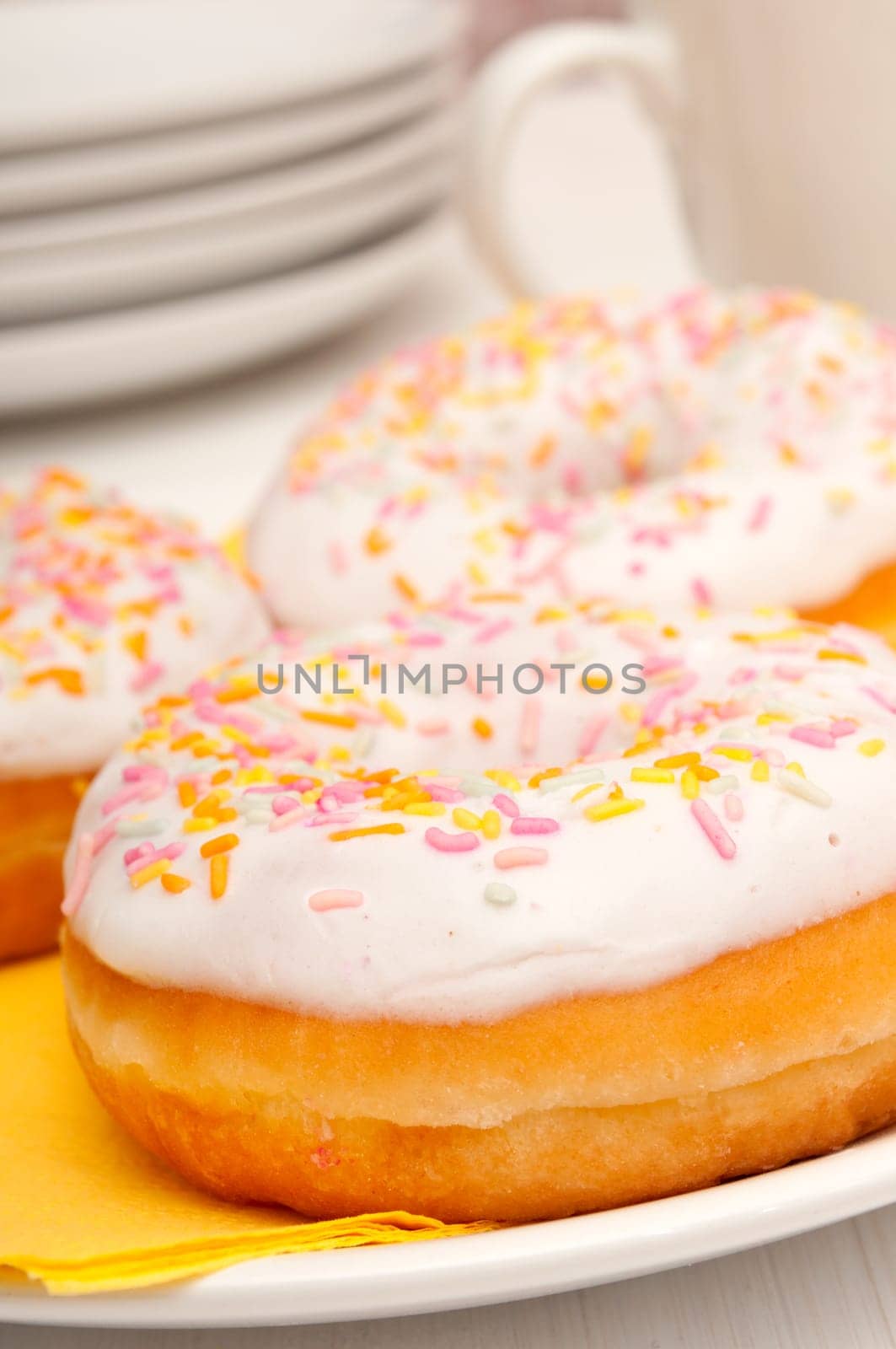 Donuts With Colorful Sprinkles, Plates and Mugs on Table
