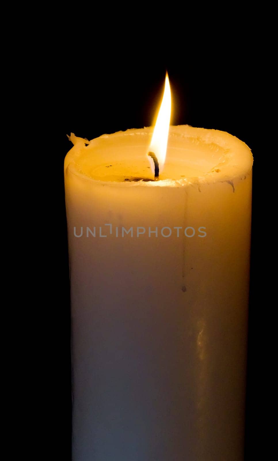 White candle is burning with a flame