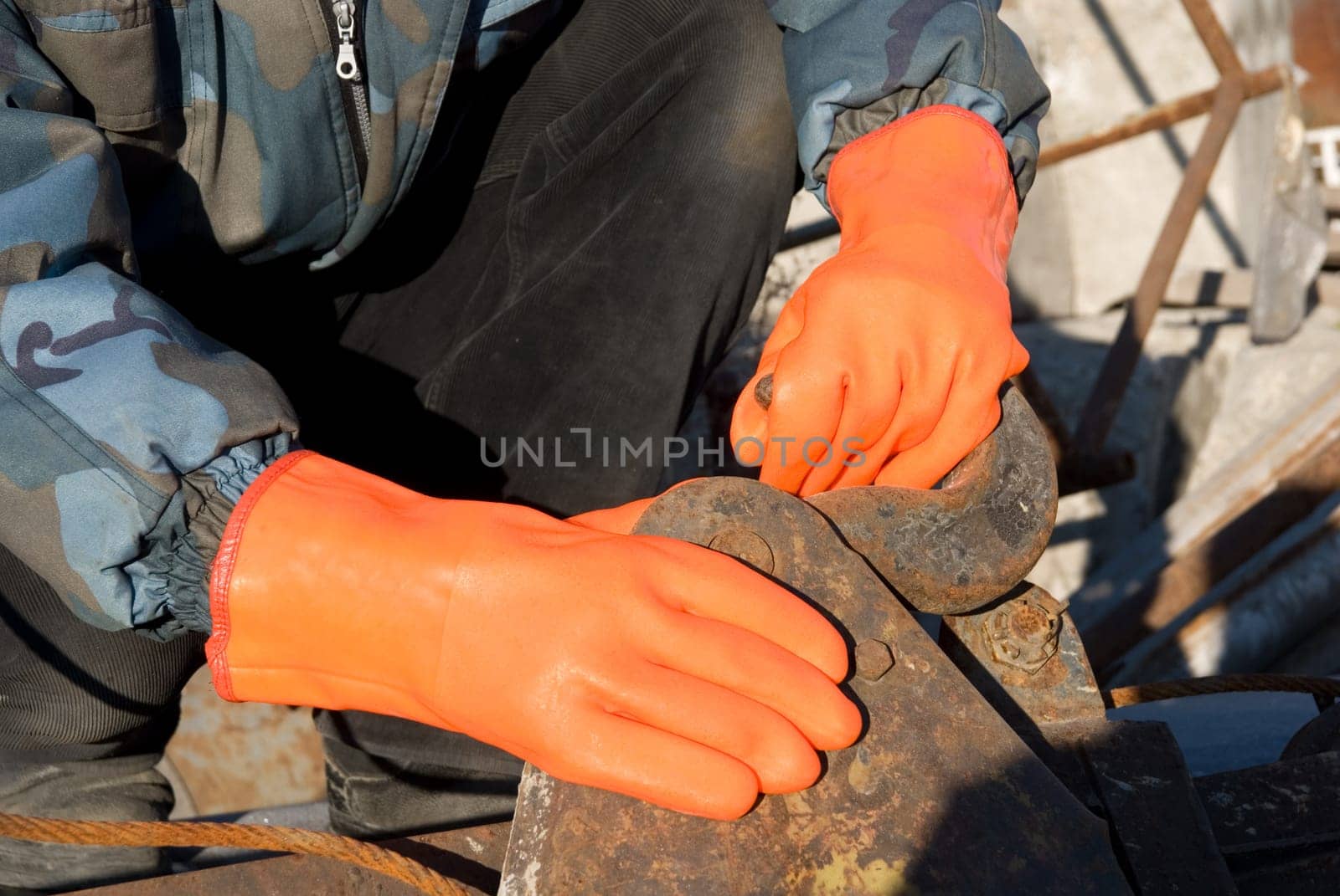 Closeup of worker man at orange gloves