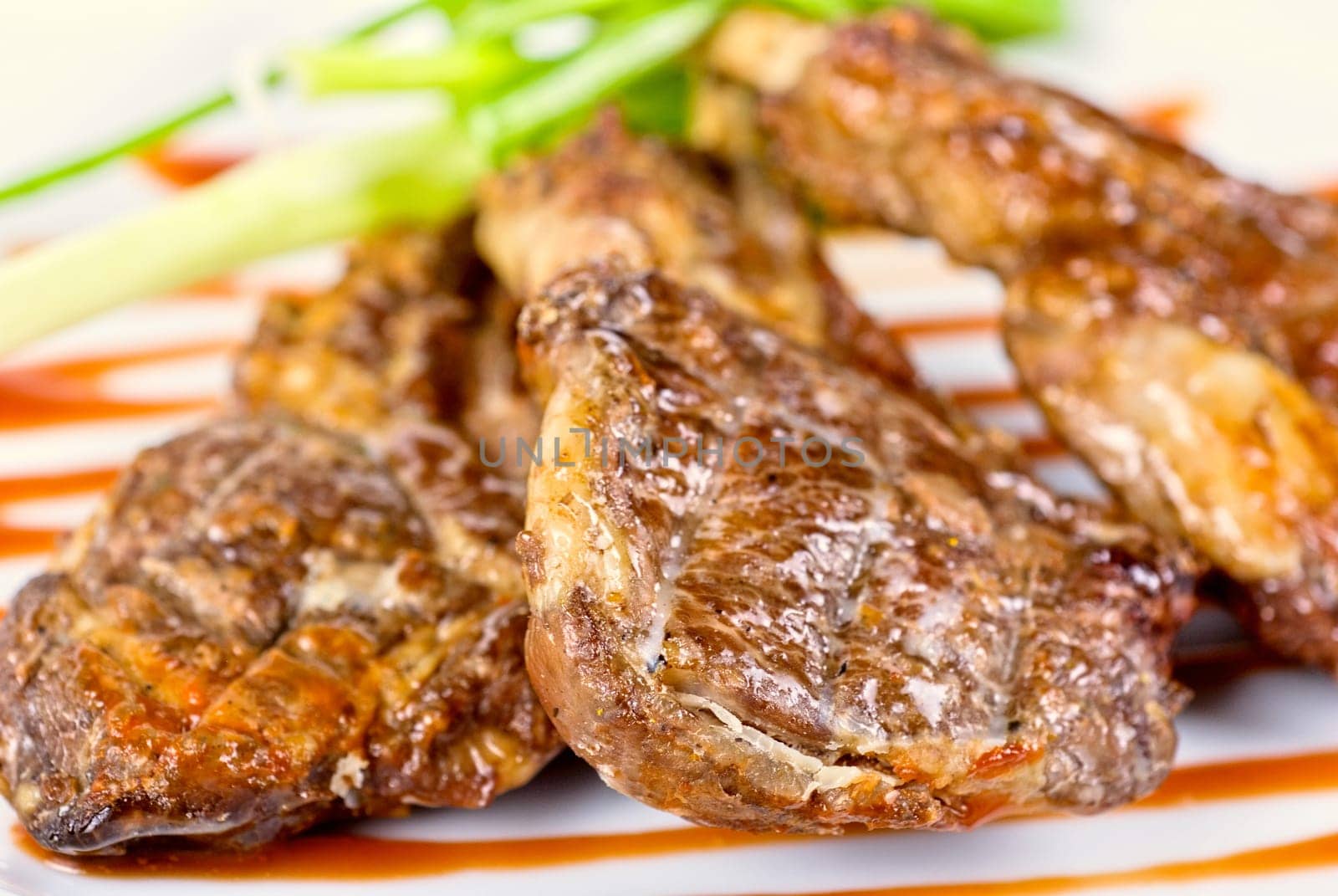 Roasted lamb meat tied with scallion closeup