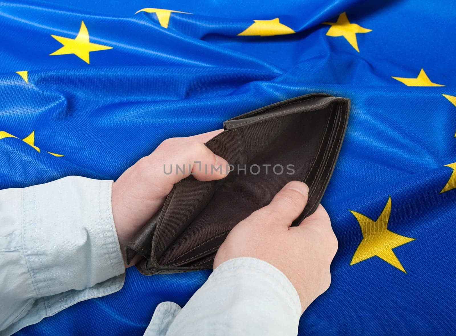 Financial Crisis in EU - Man&#039 s Hand With Empty Wallet and Flag of European Union