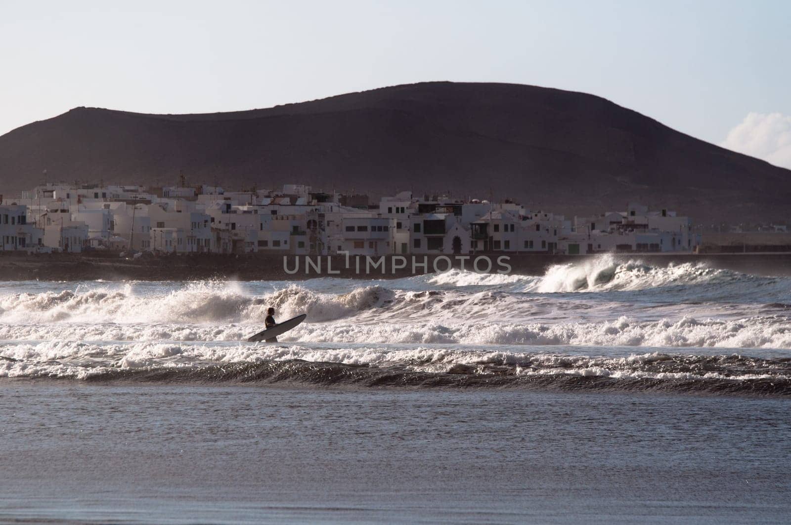 surfing the waves at sunset on Lanzarote, Canary Islands, Spain
