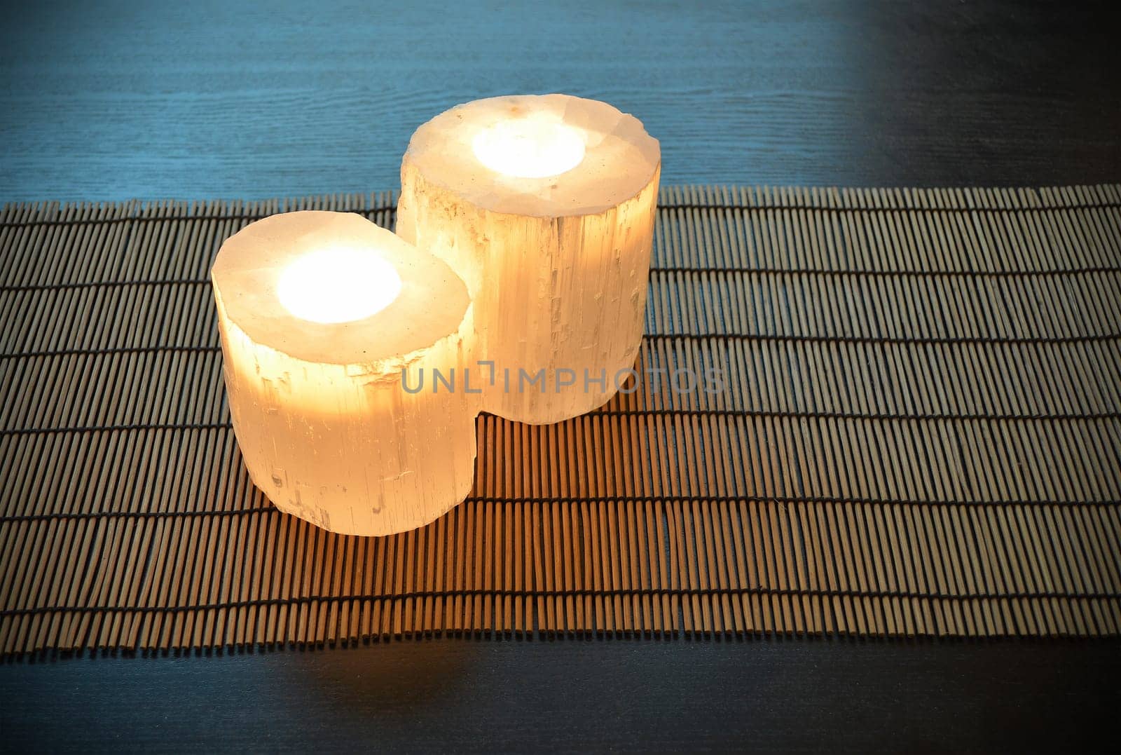 Pair of crystal candle holders, candles are lit. Peaceful atmosphere