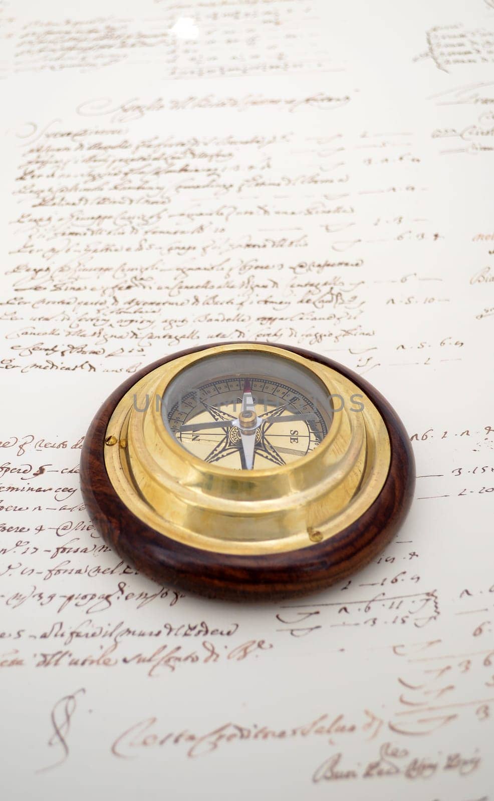 Traditional brass and wood compass on old paper