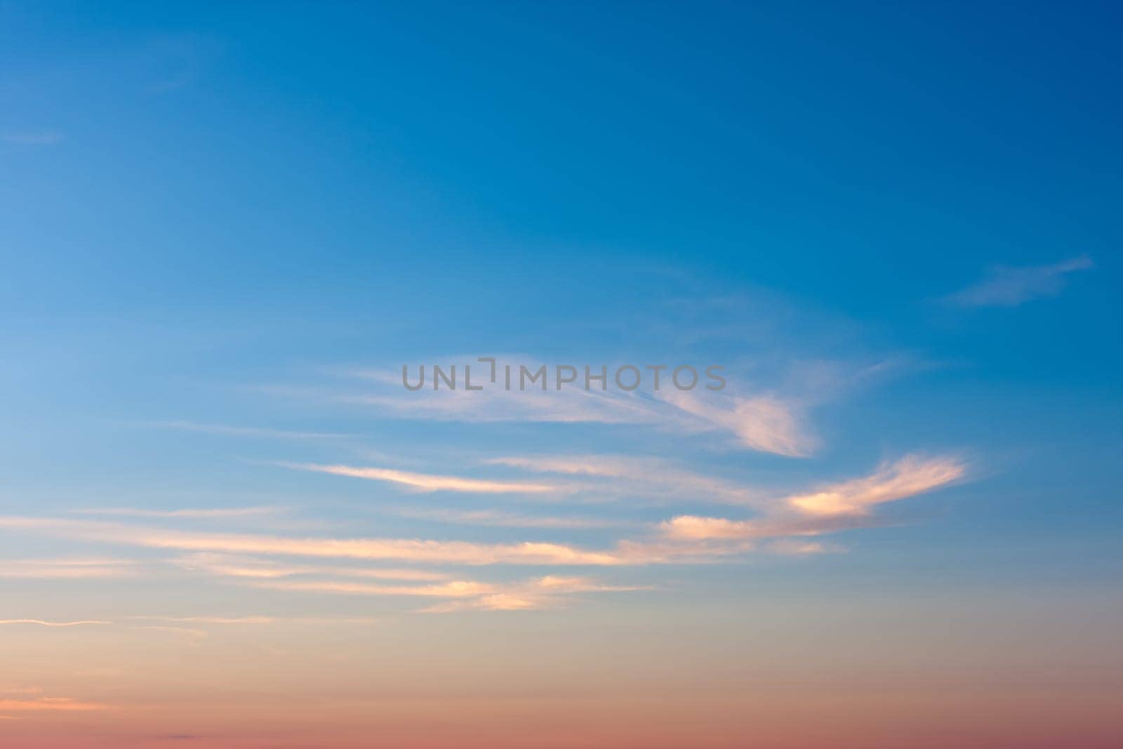 A mostly blue sky in the evening with a few clouds