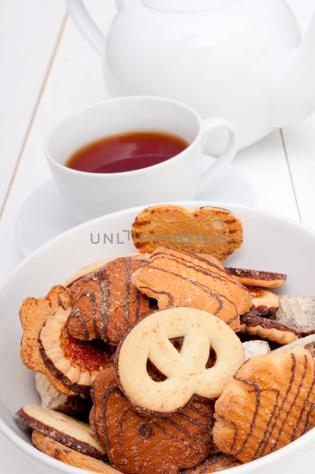 White Cup of Tea, Biscuits and Teapot on White Table