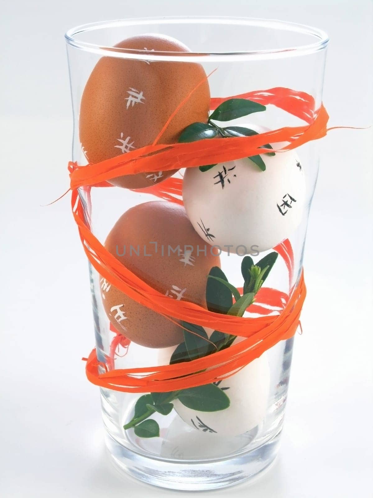 four Easter Eggs in a glass isolated on white background