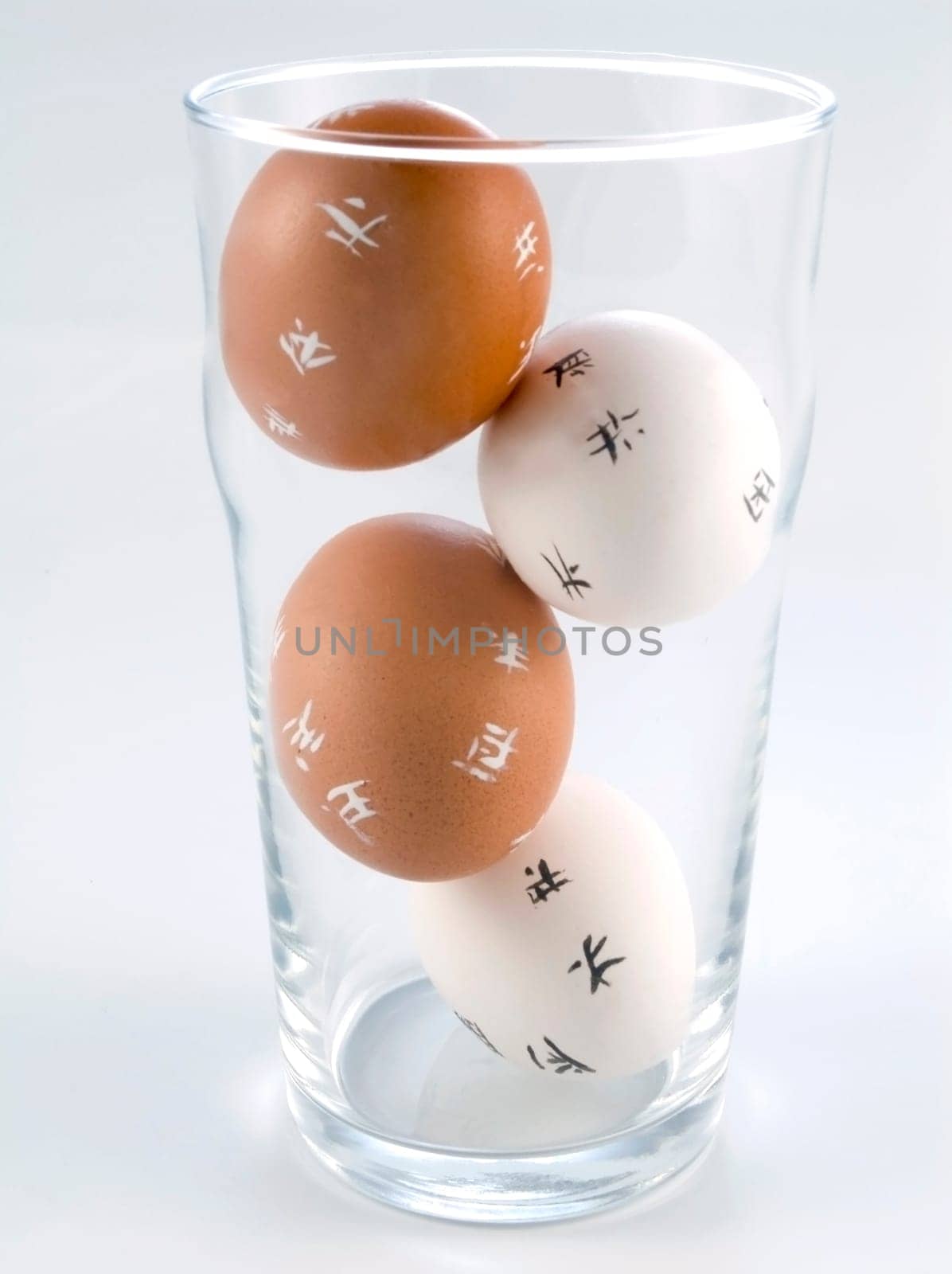 four Easter Eggs in a glass isolated on white background