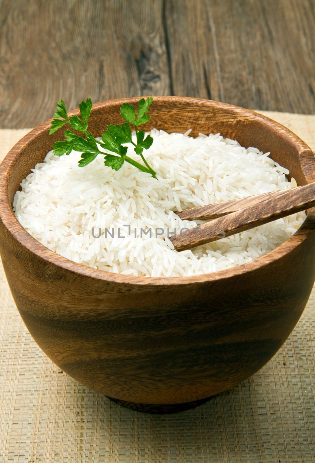 uncooked rice grains in wood bowl