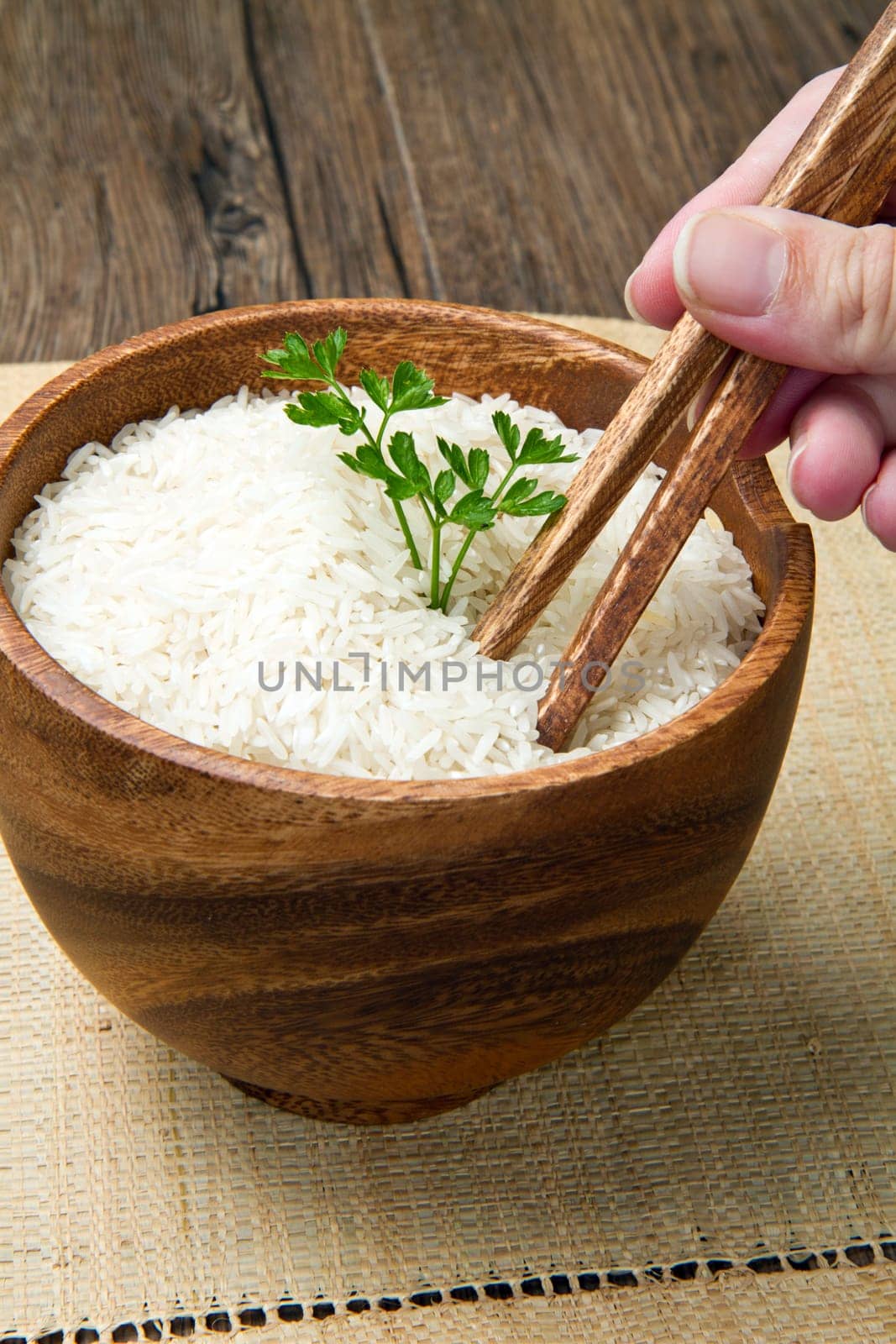 uncooked rice grains in wood bowl