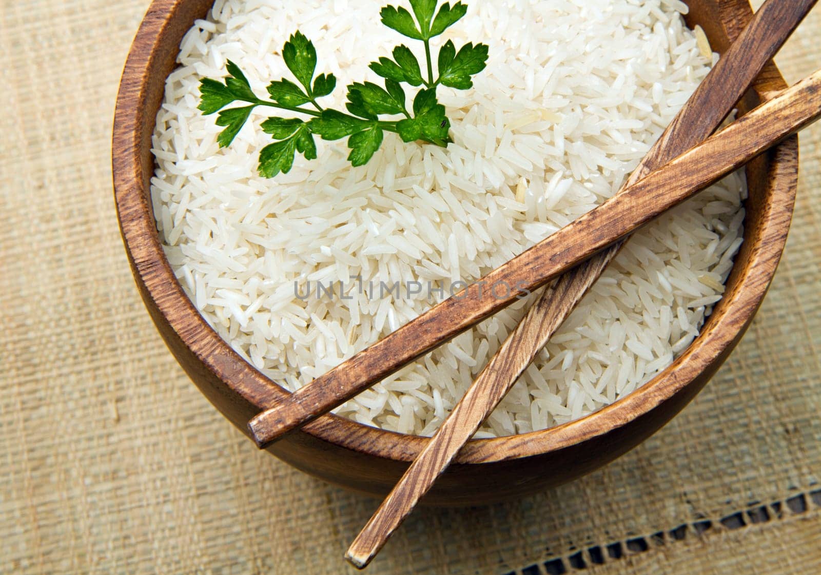uncooked rice grains in wood bowl