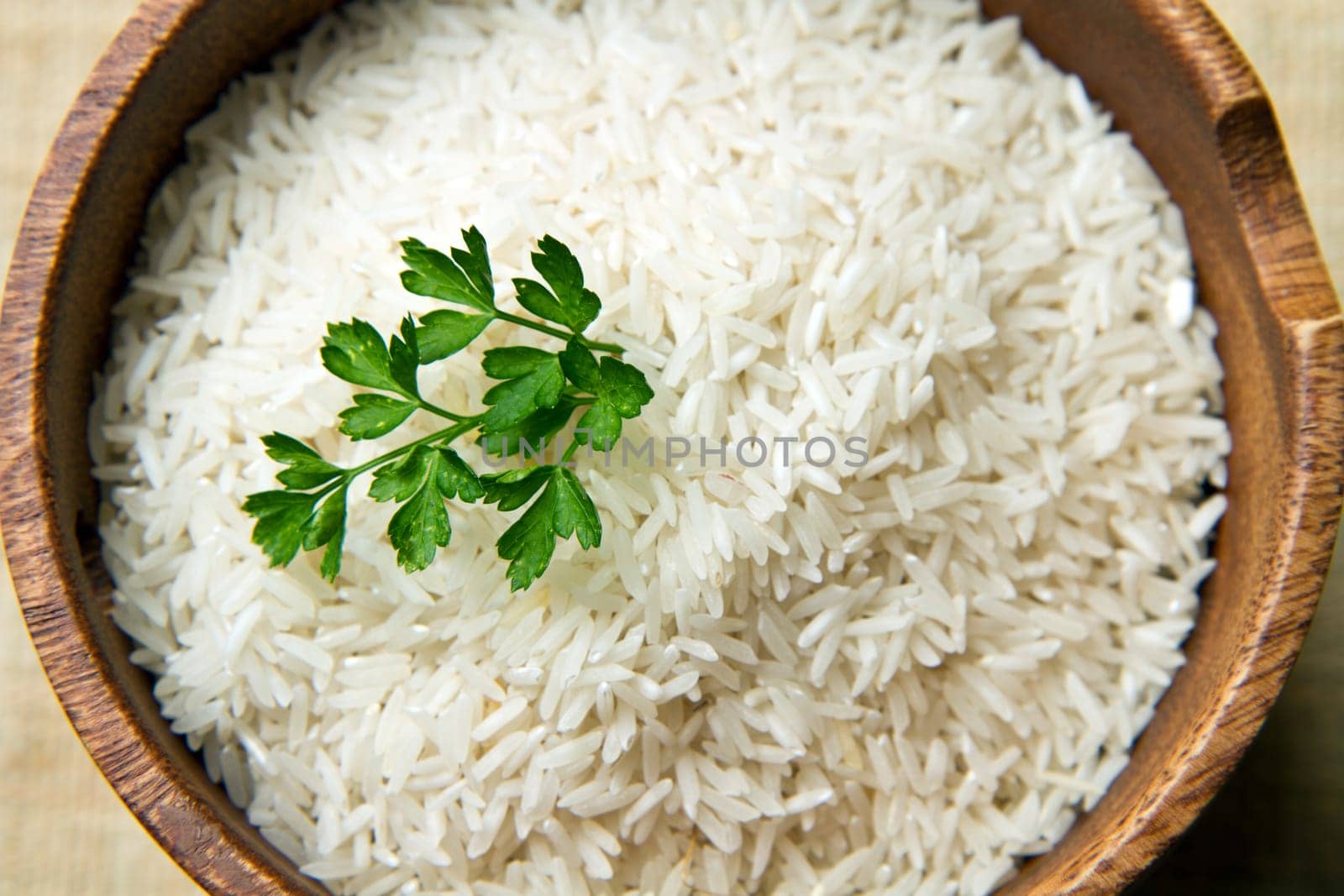 uncooked rice grains in wood bowl