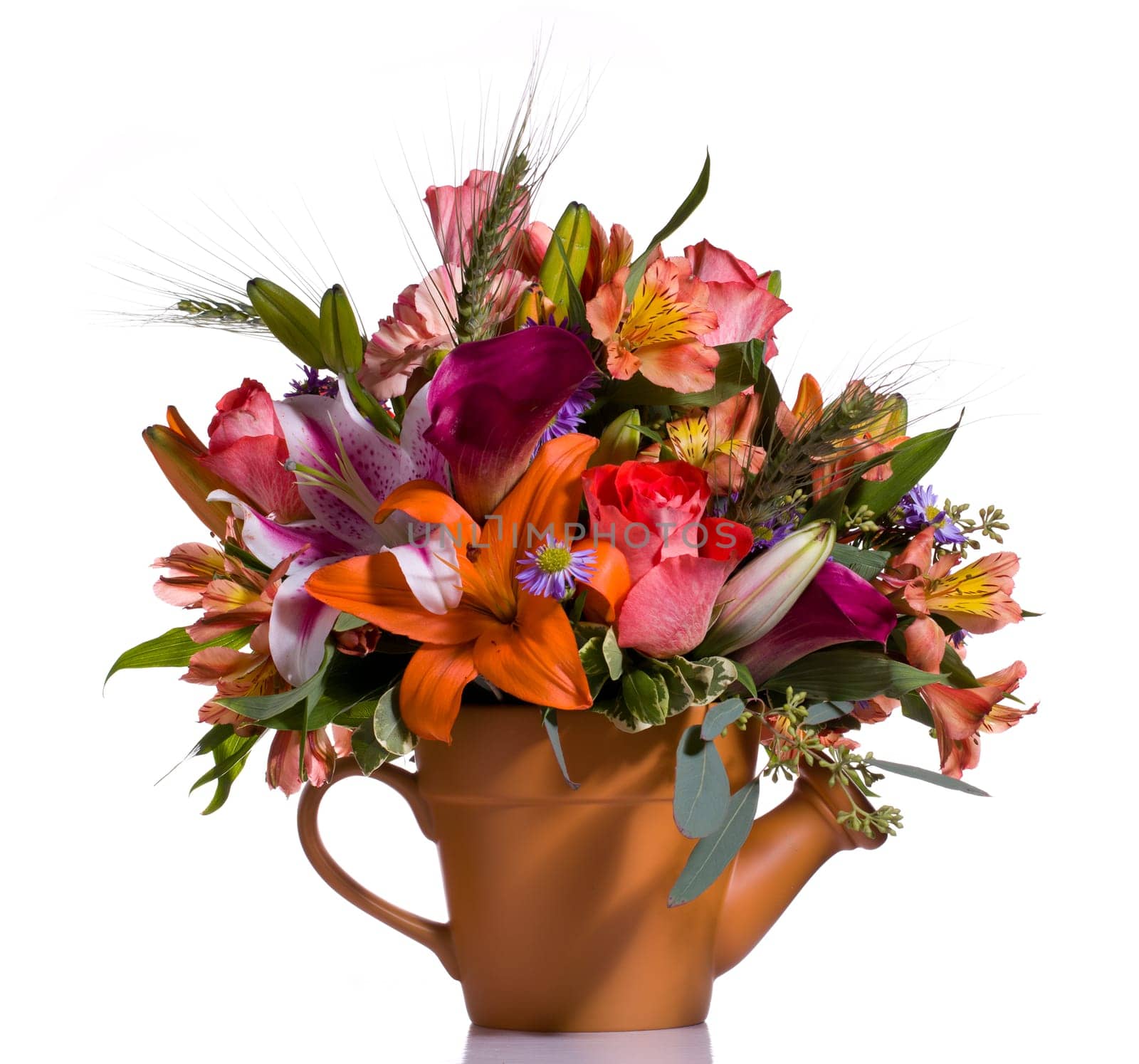 Bright and colorful bunch of flowers arranged in a watering can plant pot