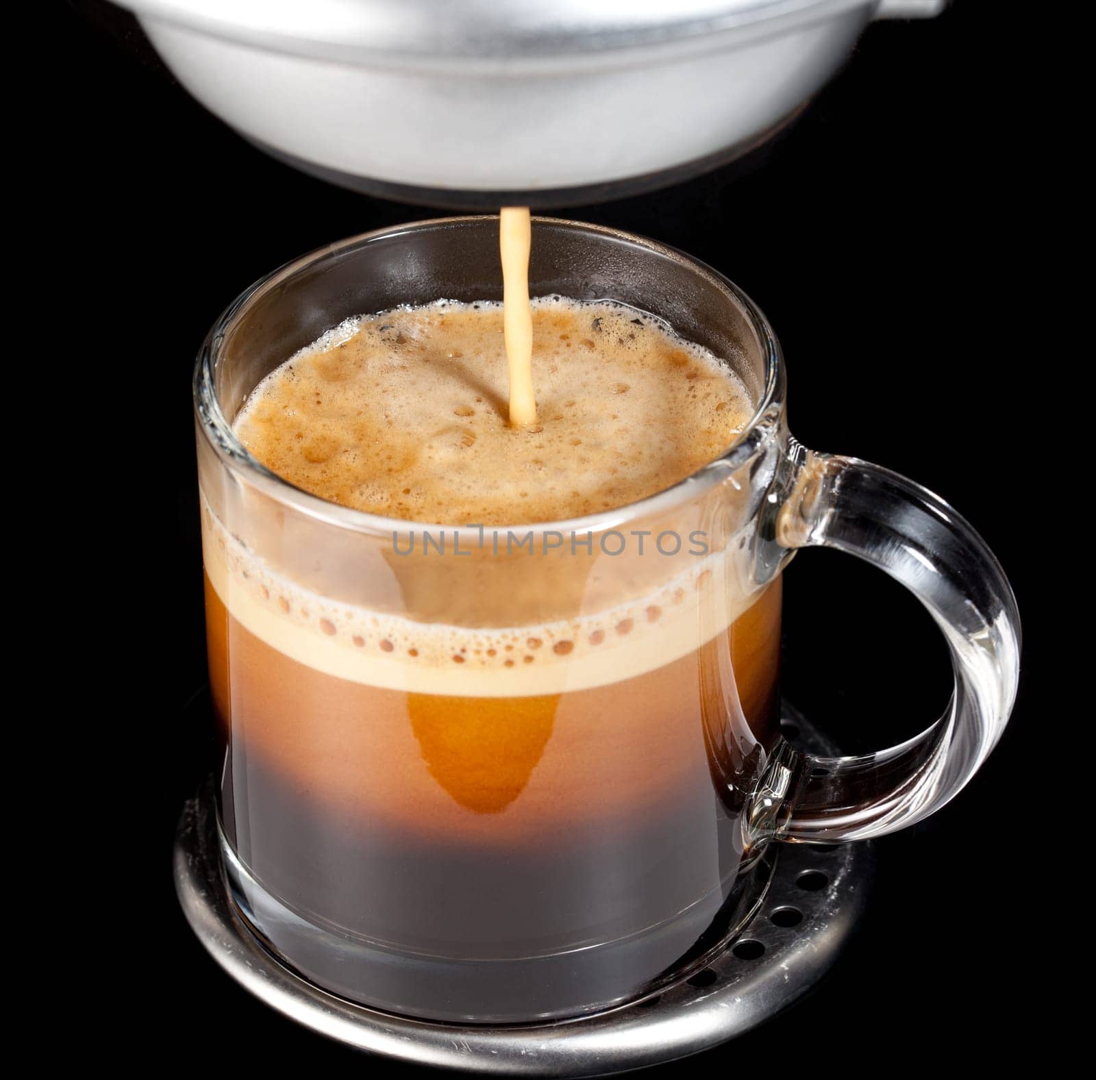 Black expresso coffee with heady froth in a glass mug or cup