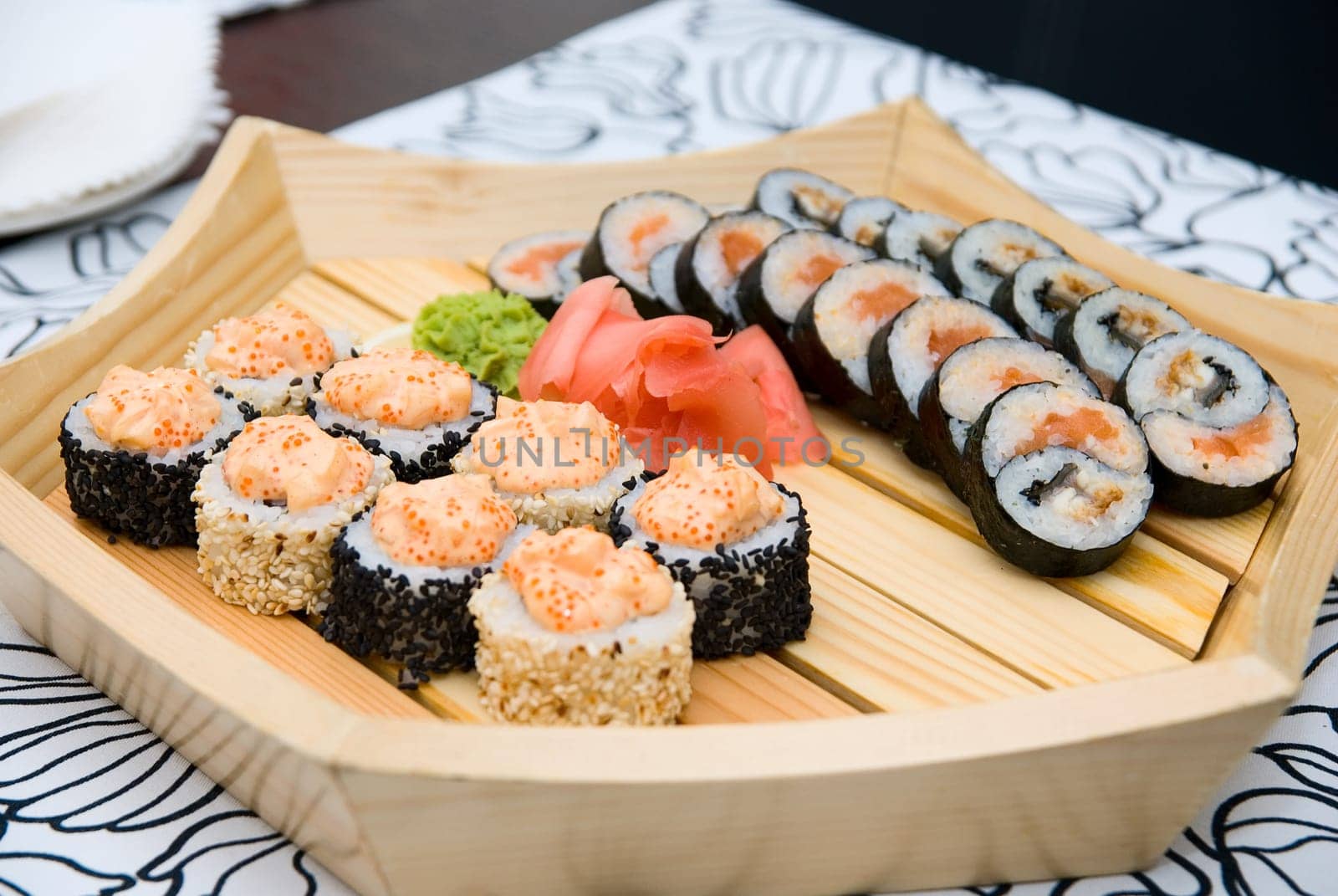 At restaurant: Set of sushi on wood plate.