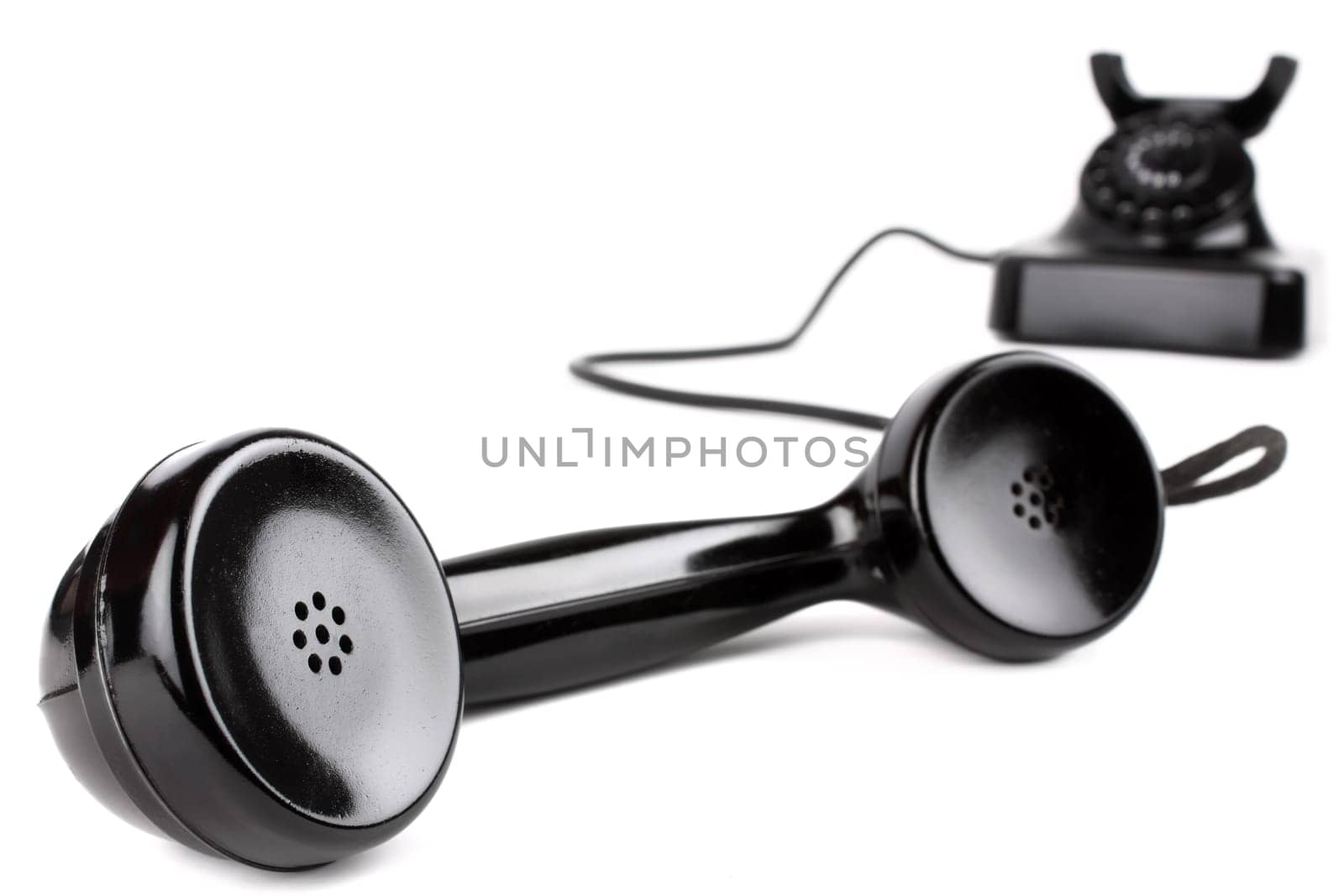 Handset in the foreground of an old telephone.