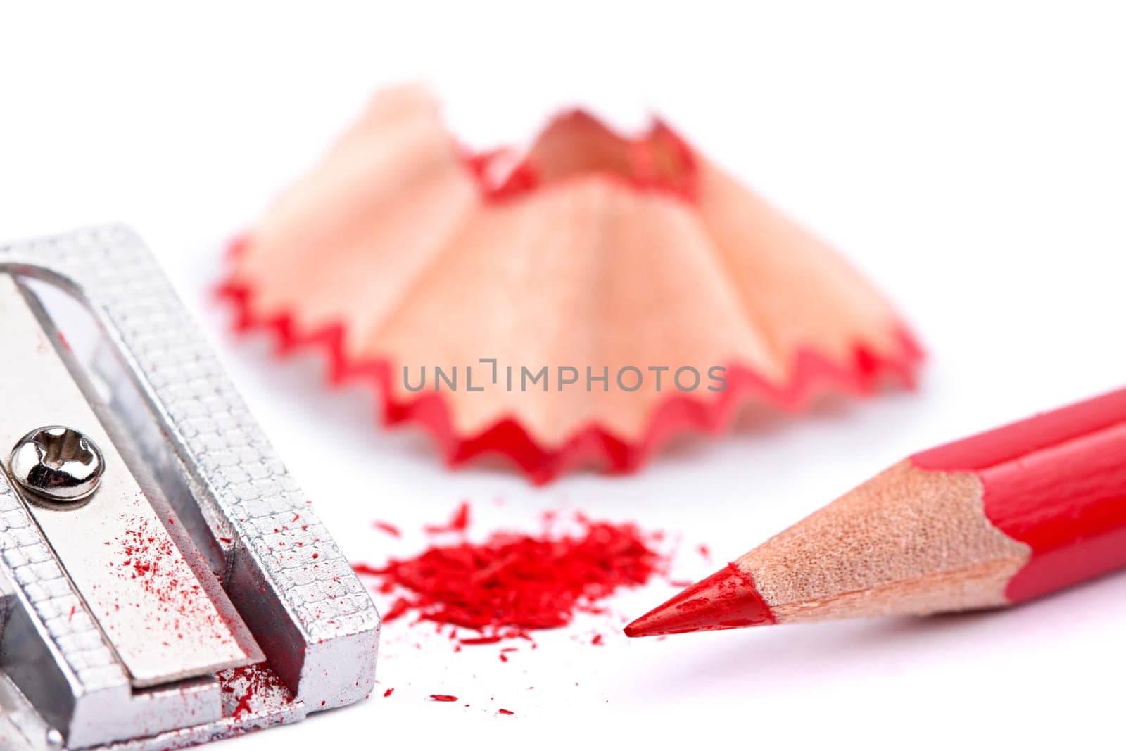 Sharpened red pencil with sharpener and shavings