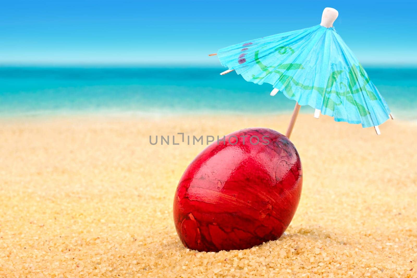 Easter egg with parasol on dream beach
