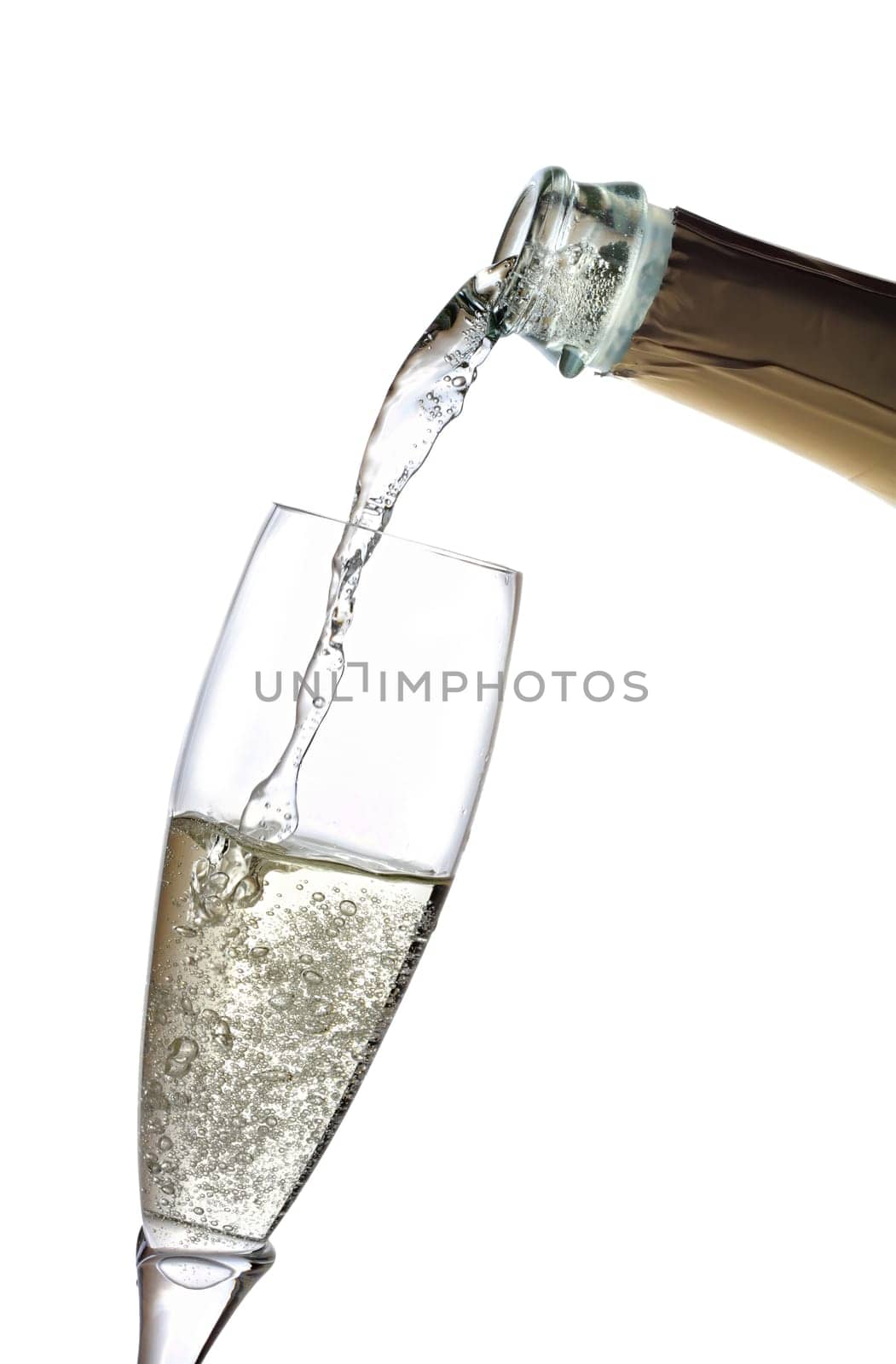 A glass of champagne is poured from a bottle.