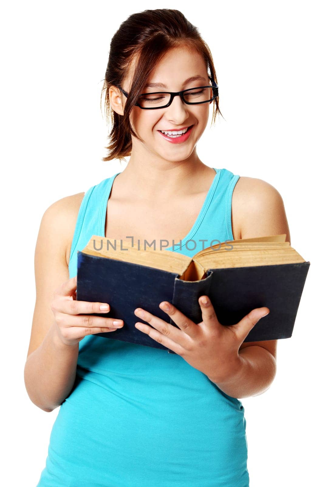 Young caucasian beautiful girl smiling and reading a blue book over white.