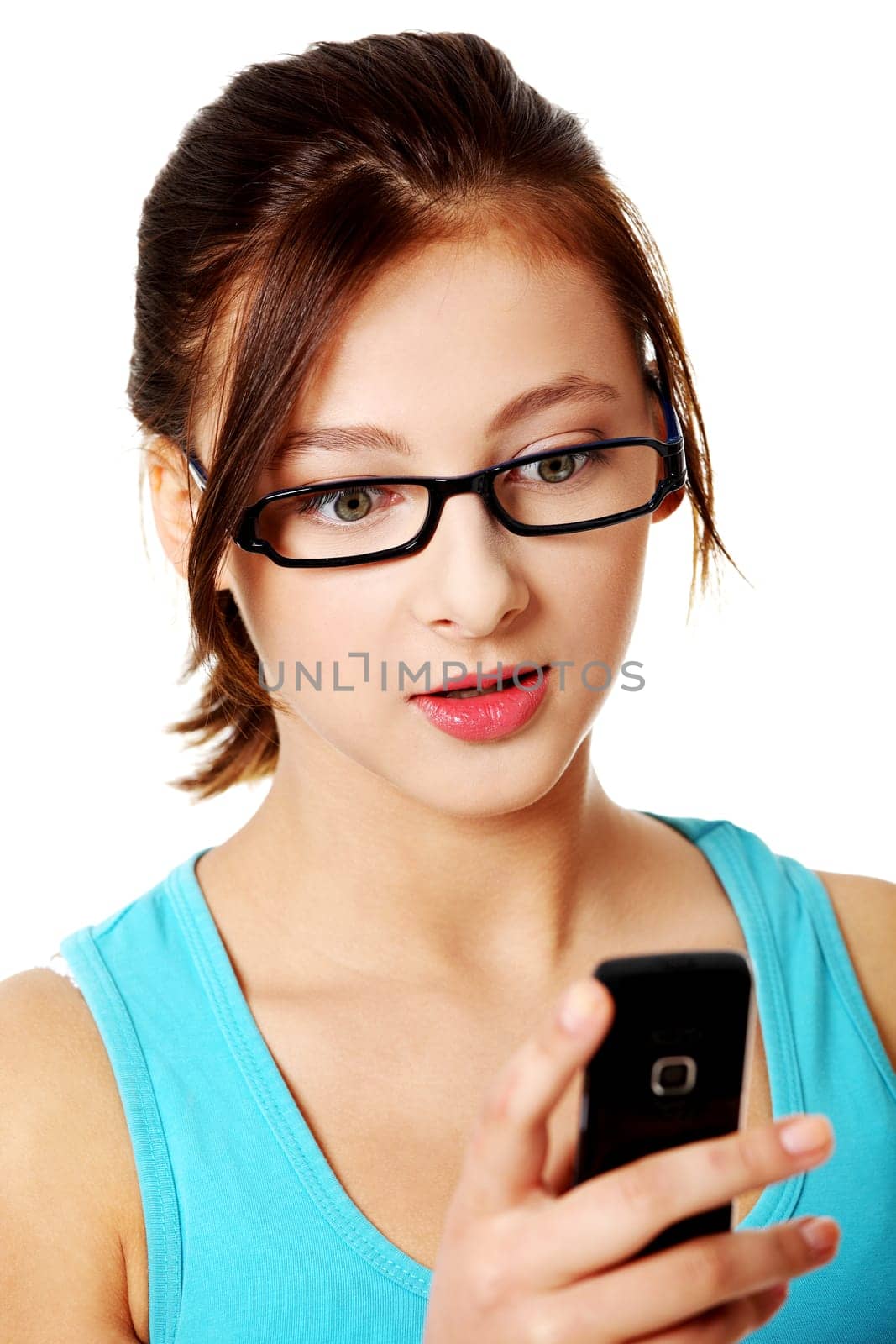 Upclose portrait of young, pretty, caucasian girl reading sms over white.