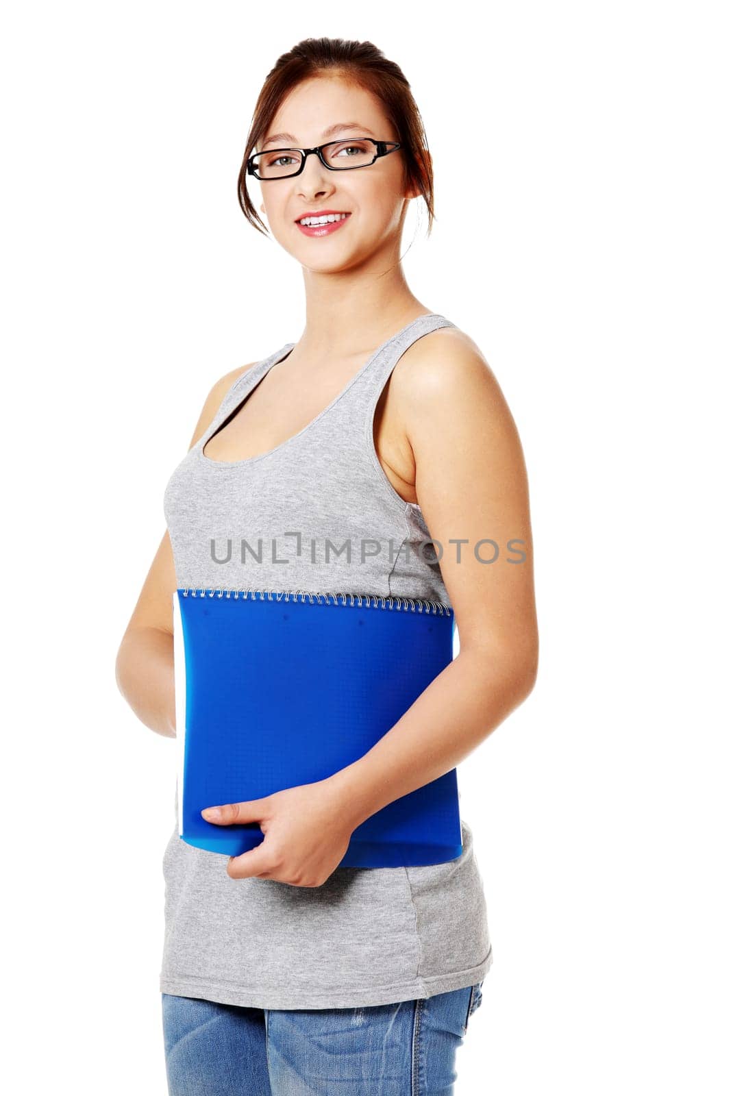 Young beautiful girl standing and holding her notebook. Isolated on white.