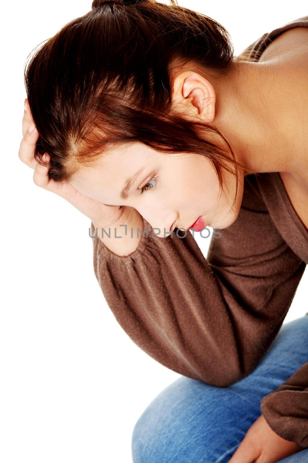 Sad caucasian pretty girl thinking and touching her head.