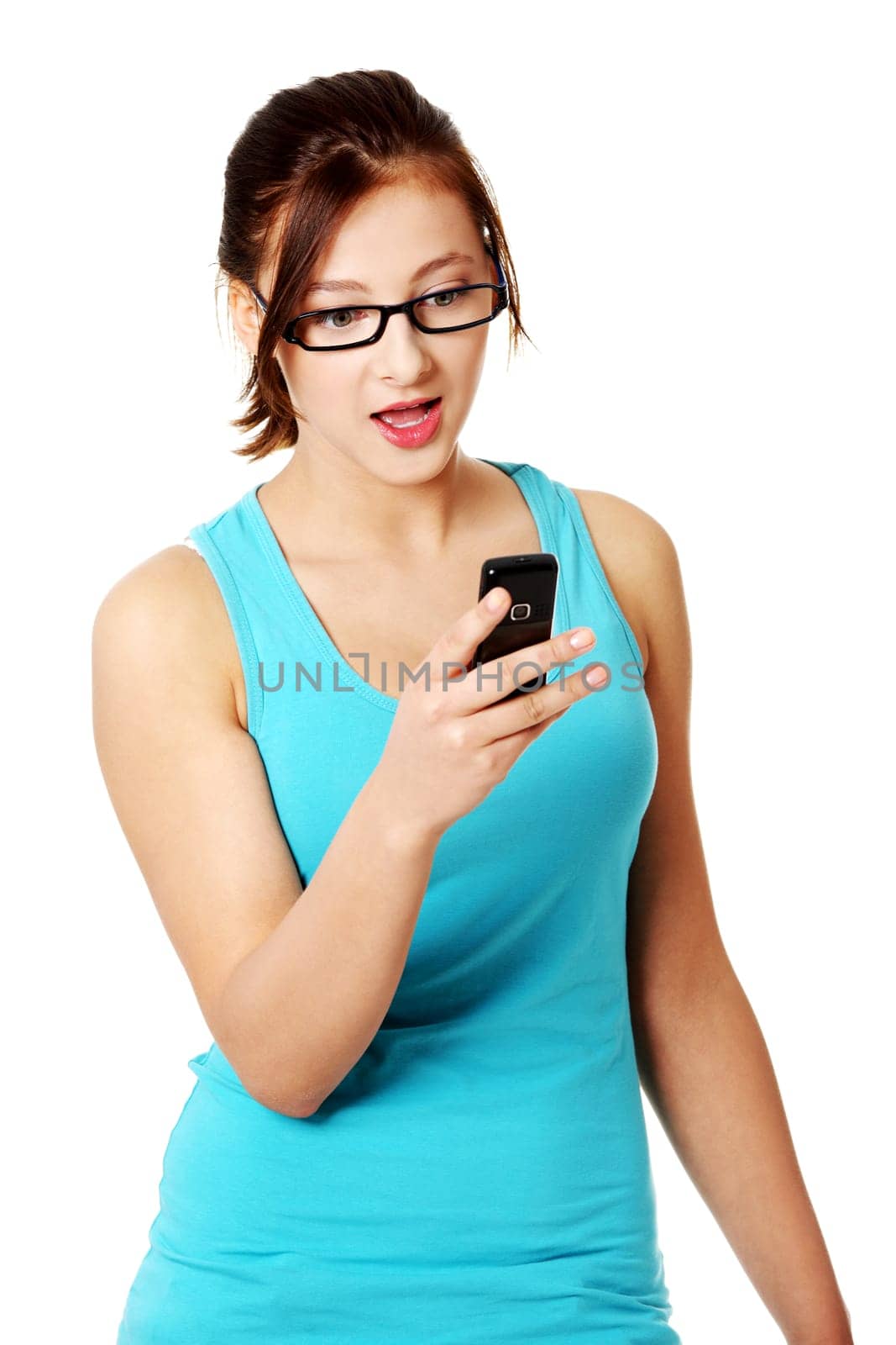Young caucasian pretty girl standing and reading sms. Isolated on white background.