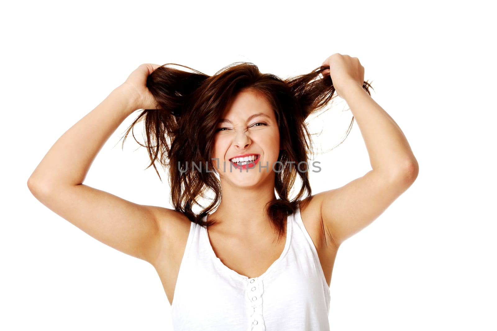 Young pretty caucasian girl pulling her hair. Isoalted on white.