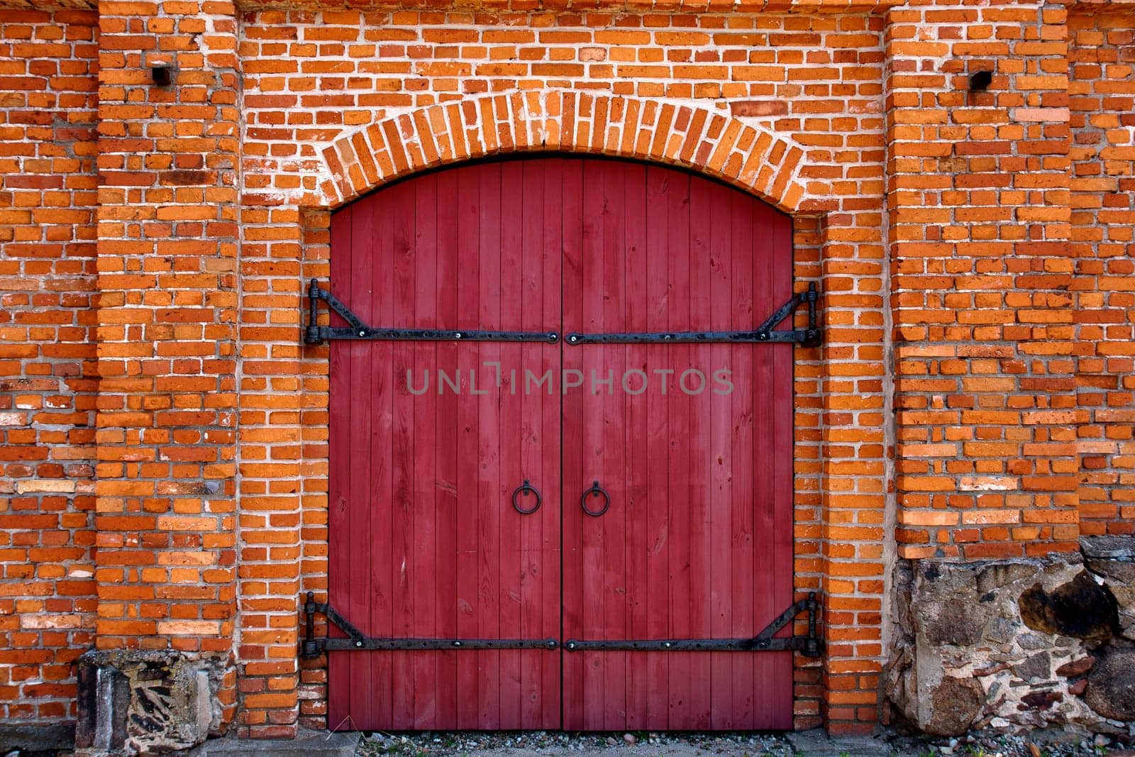 Old Red wooden door in red brick wall