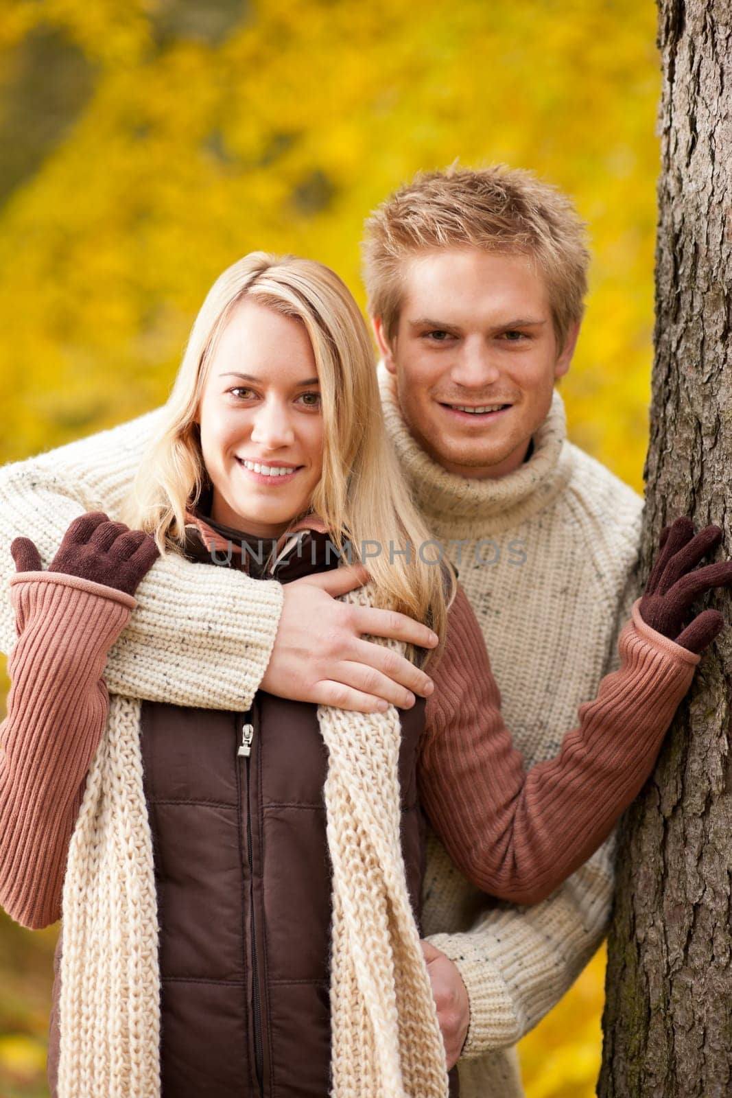 Smiling young couple in love hugging in autumn park together