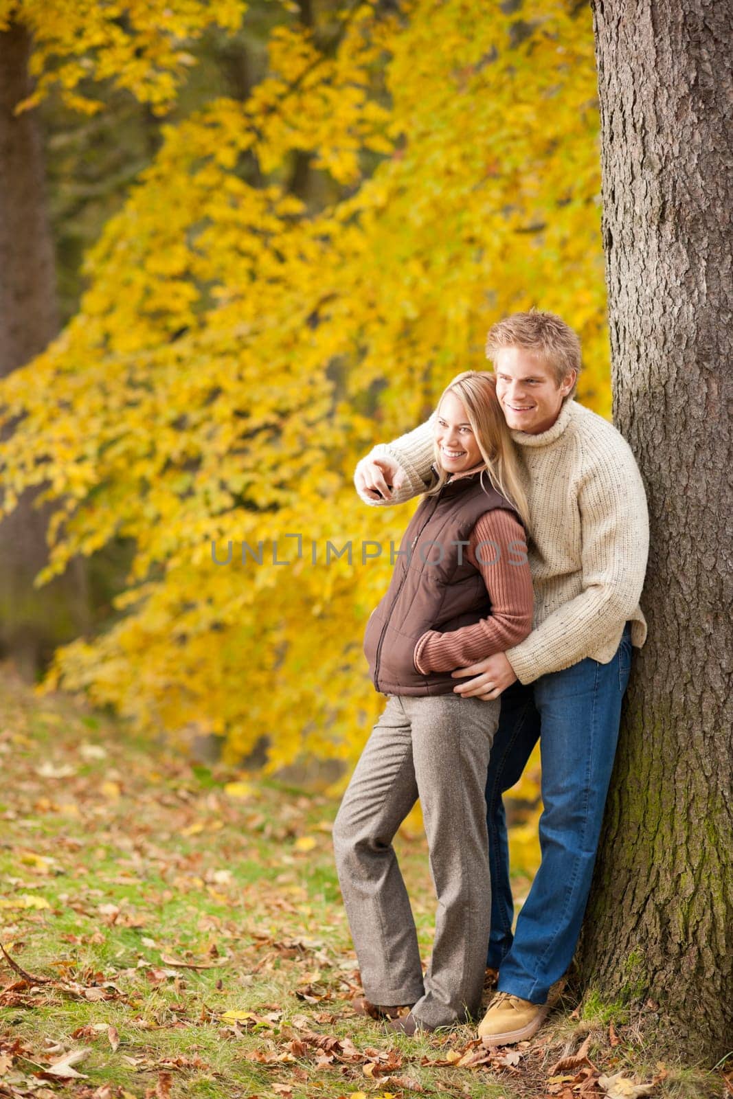 Autumn romantic couple happy together hugging in park pointing