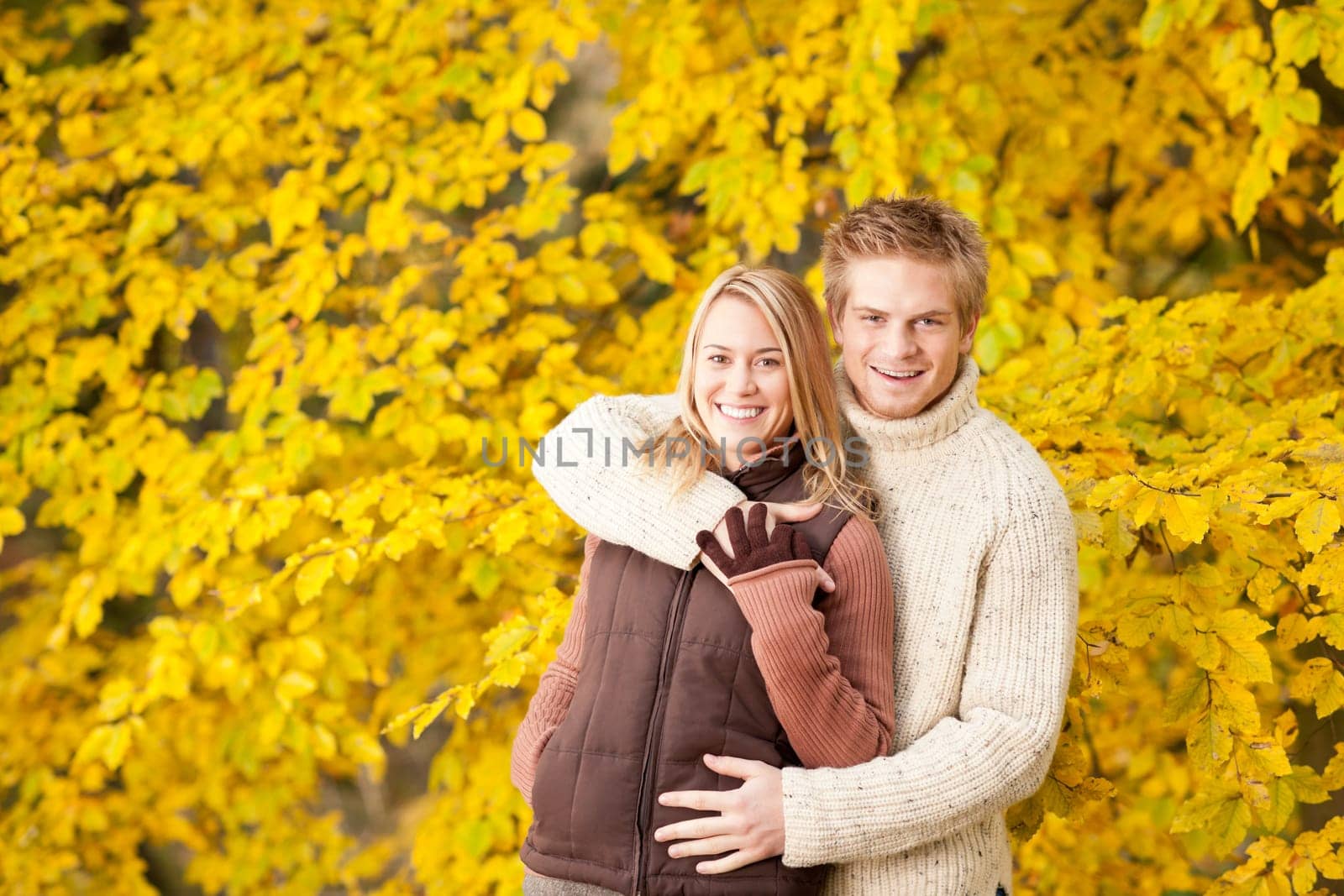 Autumn smiling young couple in love hugging in park together
