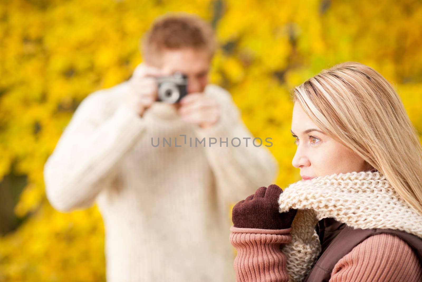 Young man make photo of posing woman profile in autumn park