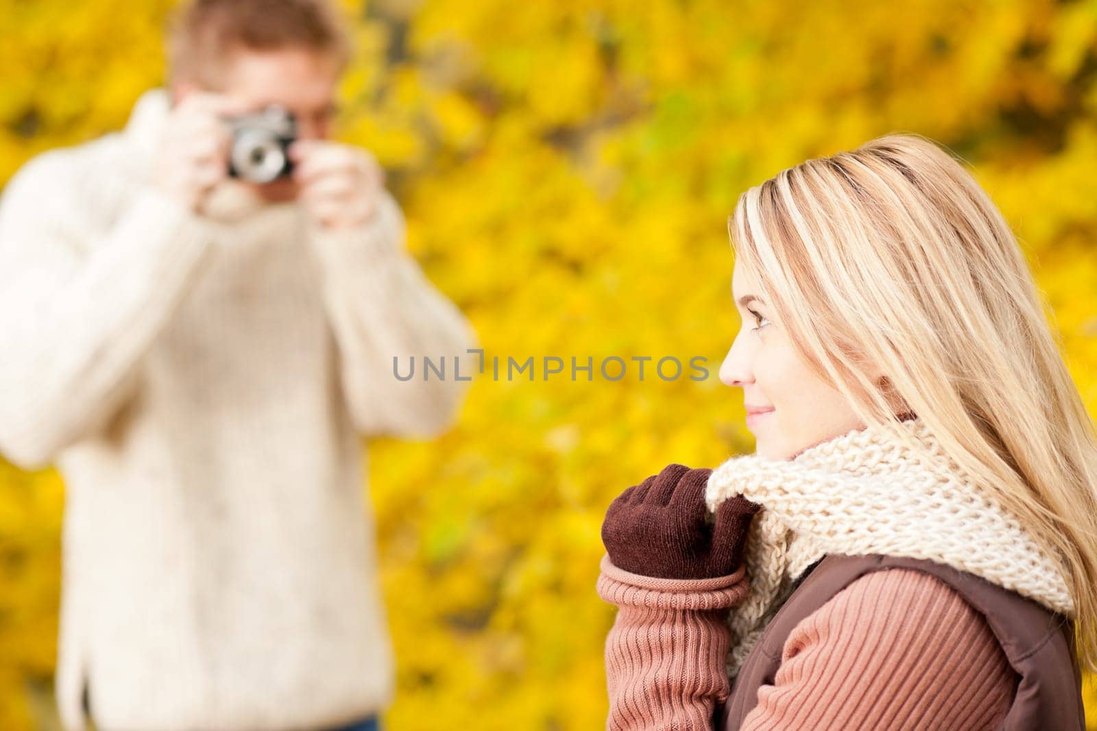 Young man make photo of posing woman profile in autumn park