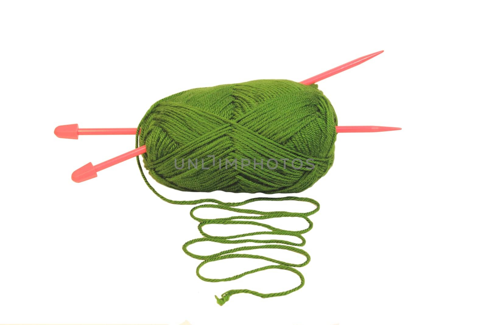 A green ball of wool with pink knitting needles poking through