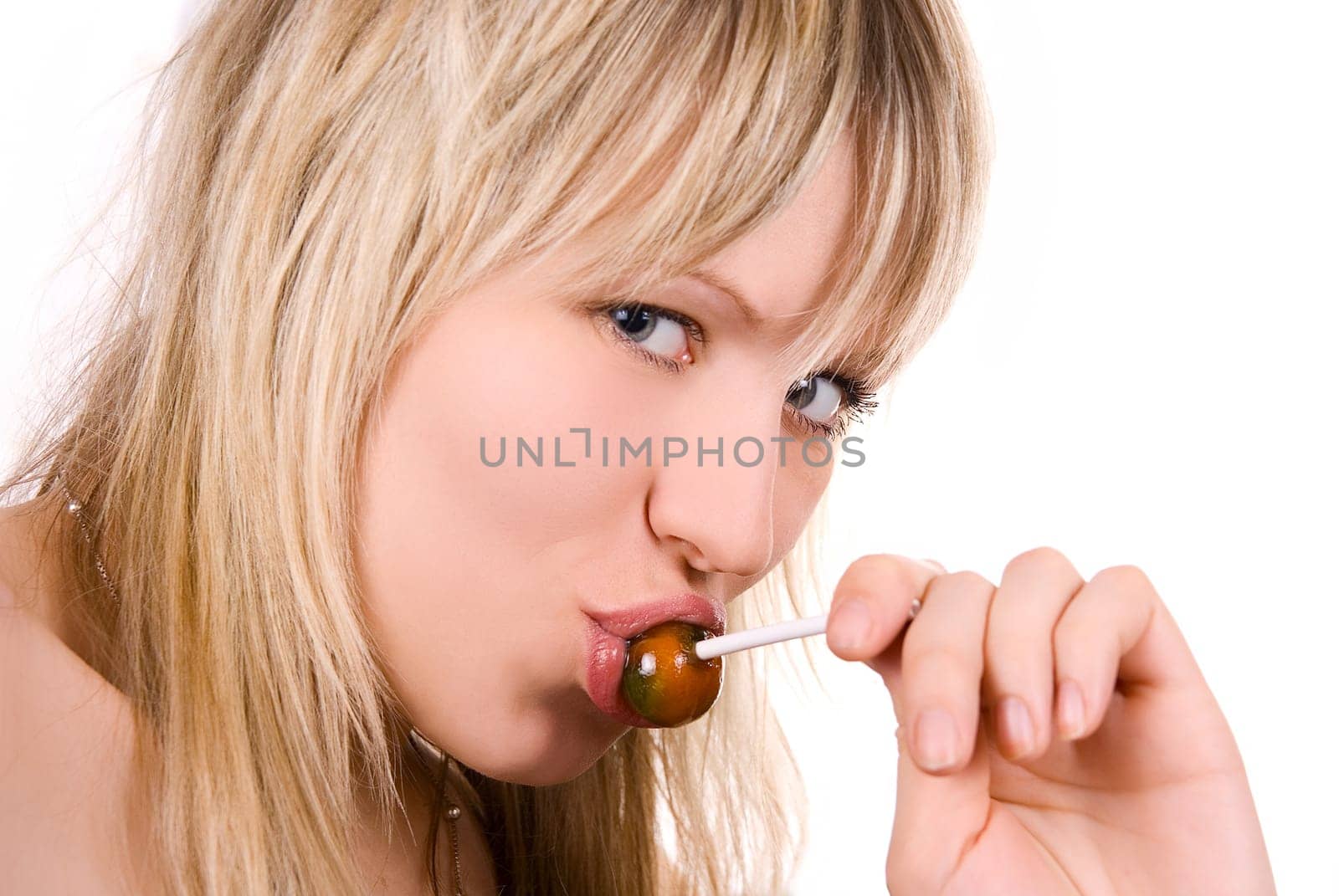 Lovely young women sucking lollipop on white