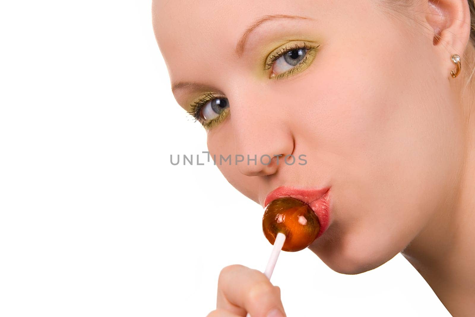 Beautiful girl sucking lollipop on white