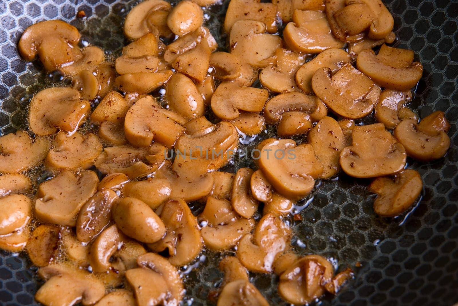 Grinded mushrooms champignon roasting in pan.