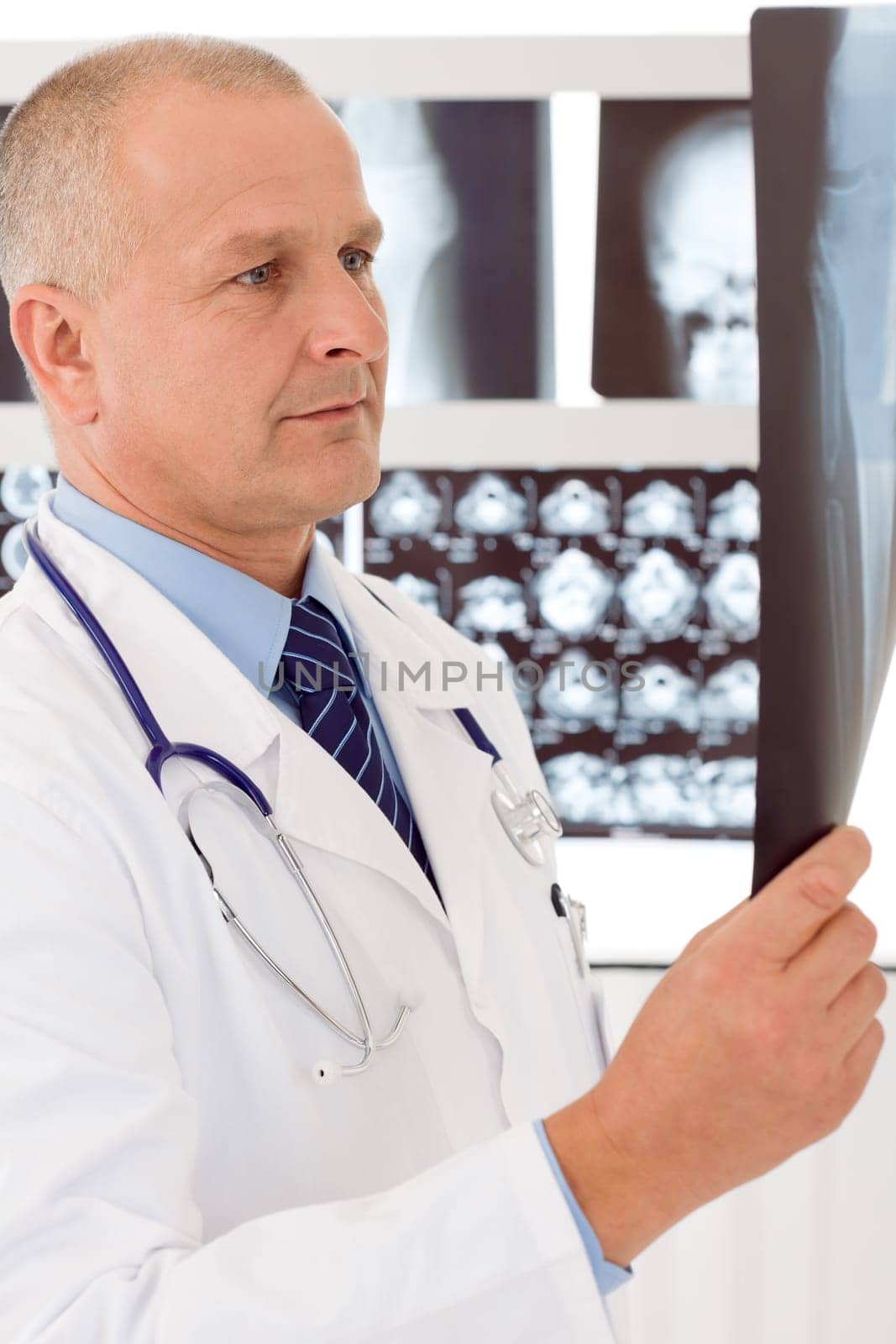 Male doctor standing at front of set x-ray looking