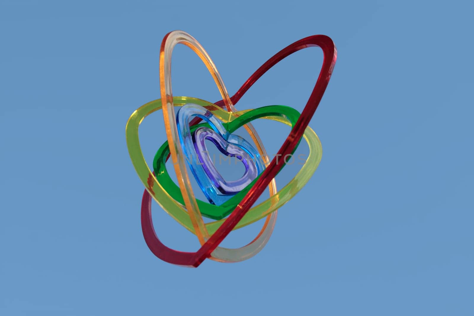 six heart shaped plastic pieces one inside the other on a blue background as if floating on air
