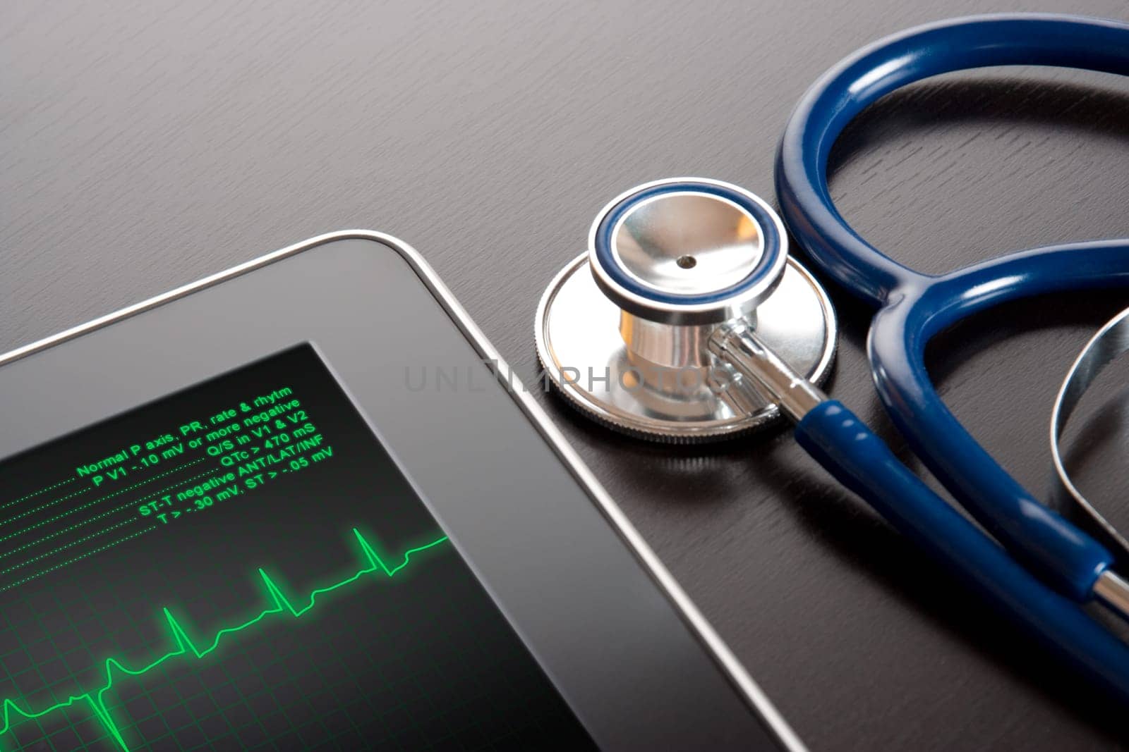 Doctor workplace with tablet display electrocardiogram (ECG) and stethoscope