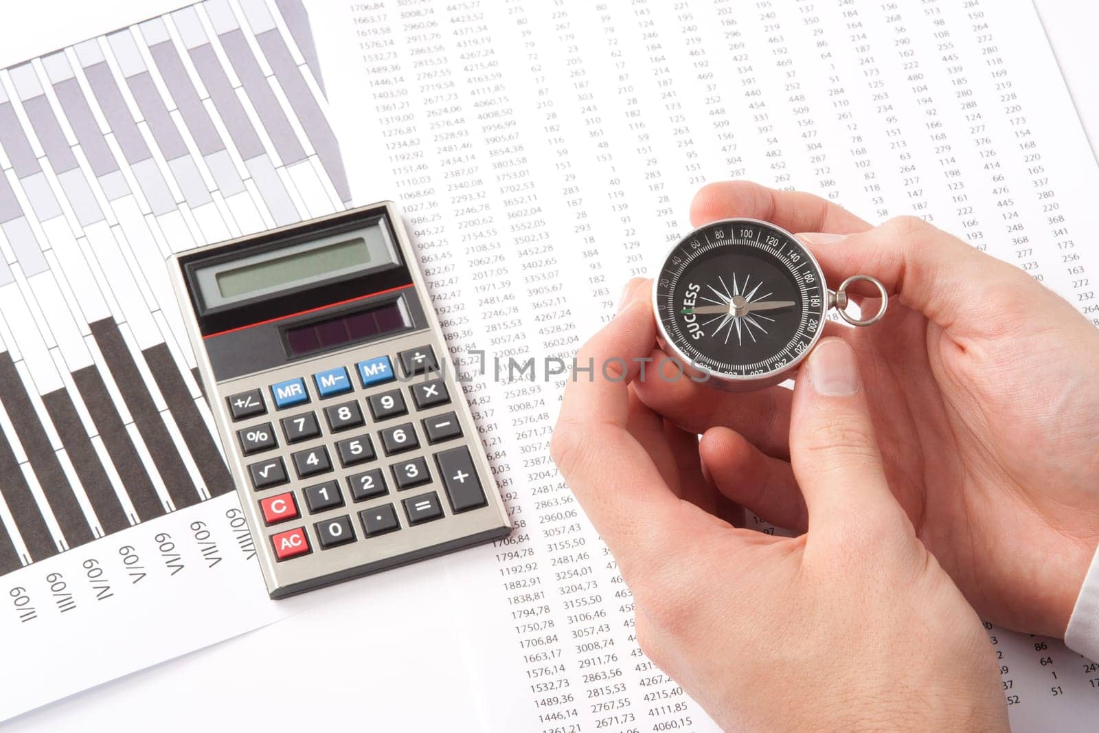 Navigate to success in business and compare right direction in business concept. Man with compass directed to success word. Calculator, sheet and graph represent business.